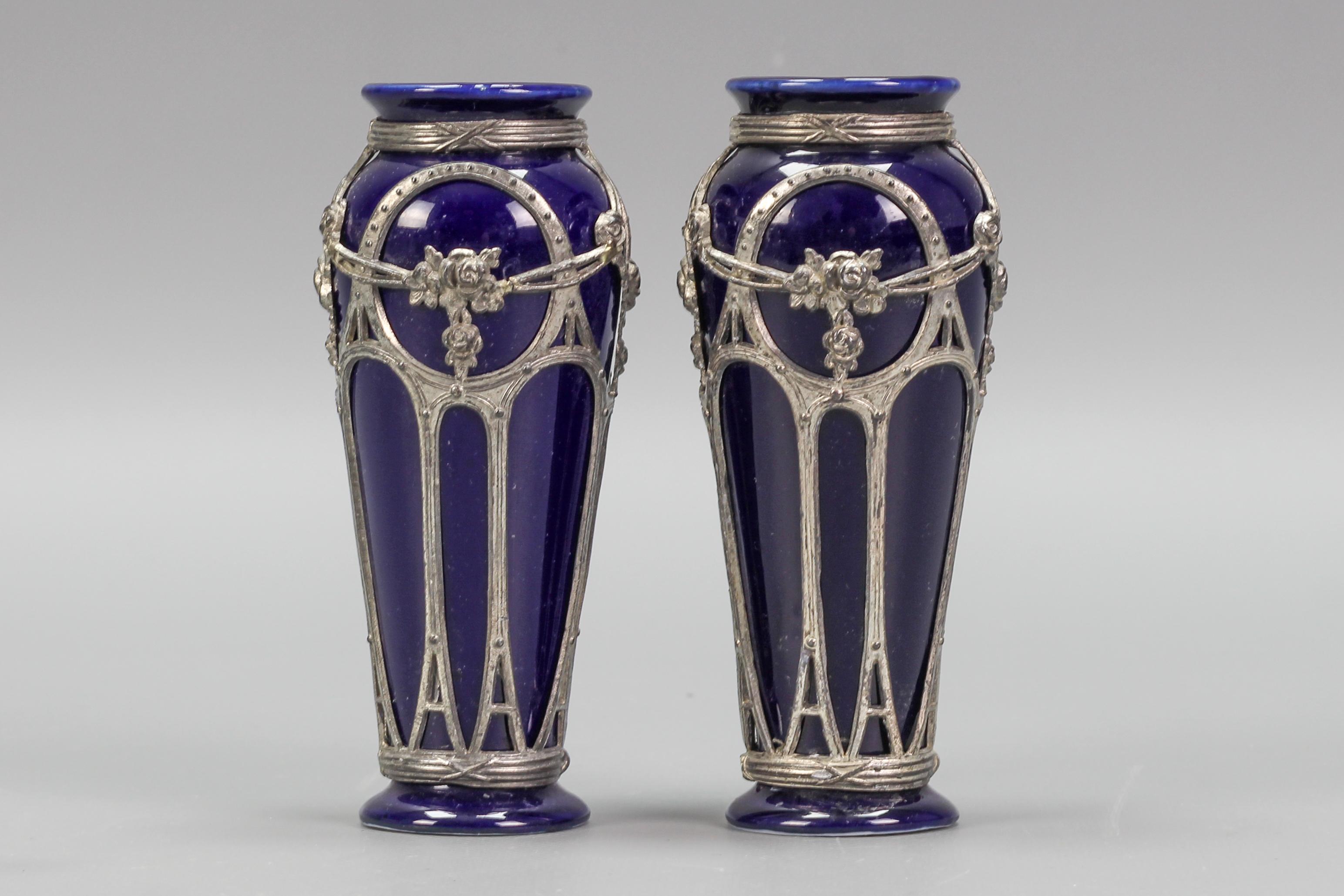 An adorable pair of small Art Nouveau period vases. These beautiful vases are made of glazed ceramic in indigo blue color and adorned with decorative pewter mountings. Germany, circa 1910.
Dimensions: height: 12.5 cm / 4.92 in; diameter: 5 cm /