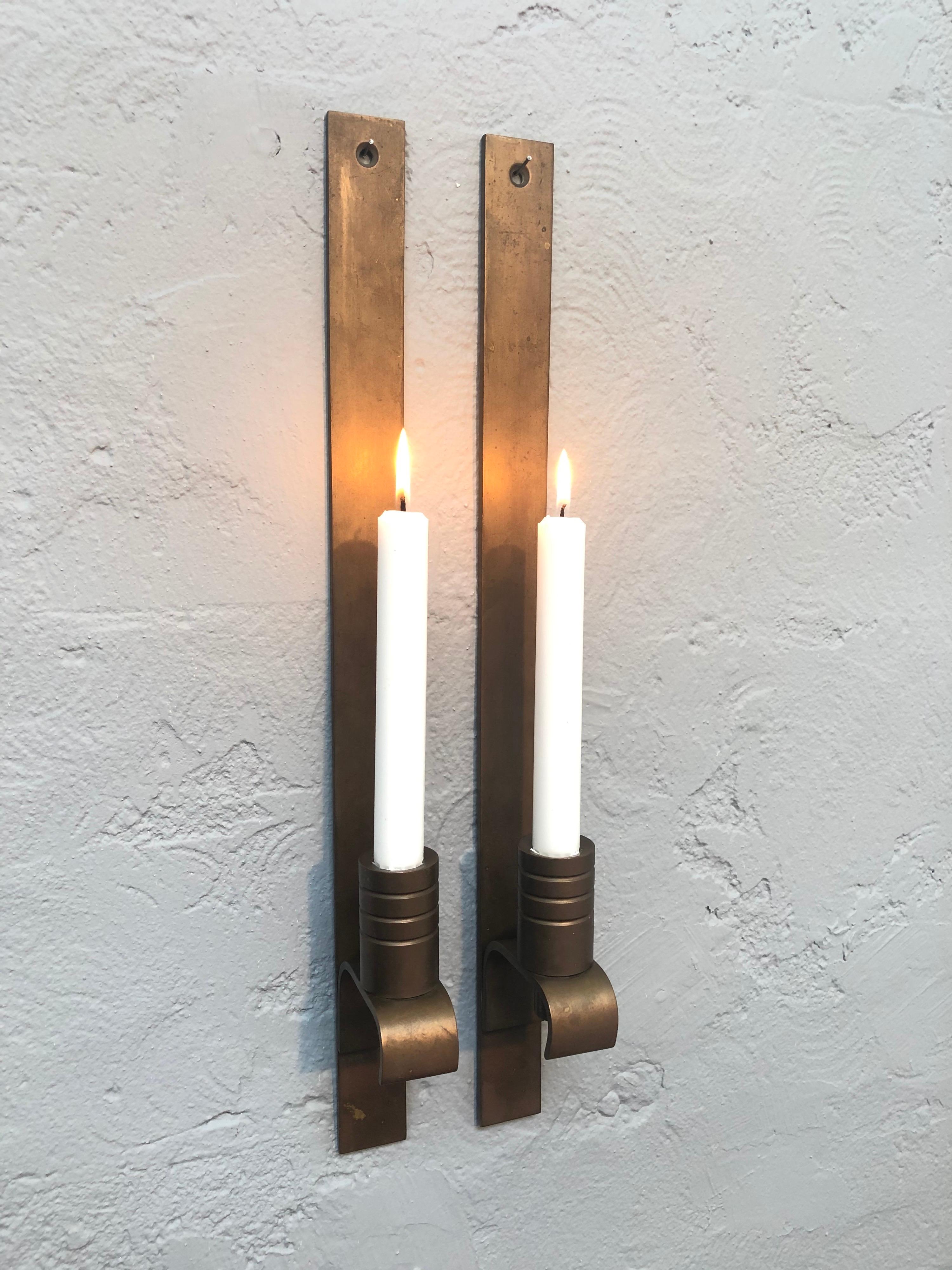 A pair of mid century Danish solid brass wall mounted Brutalist candle holders. 
In great condition with age related wear and patina.