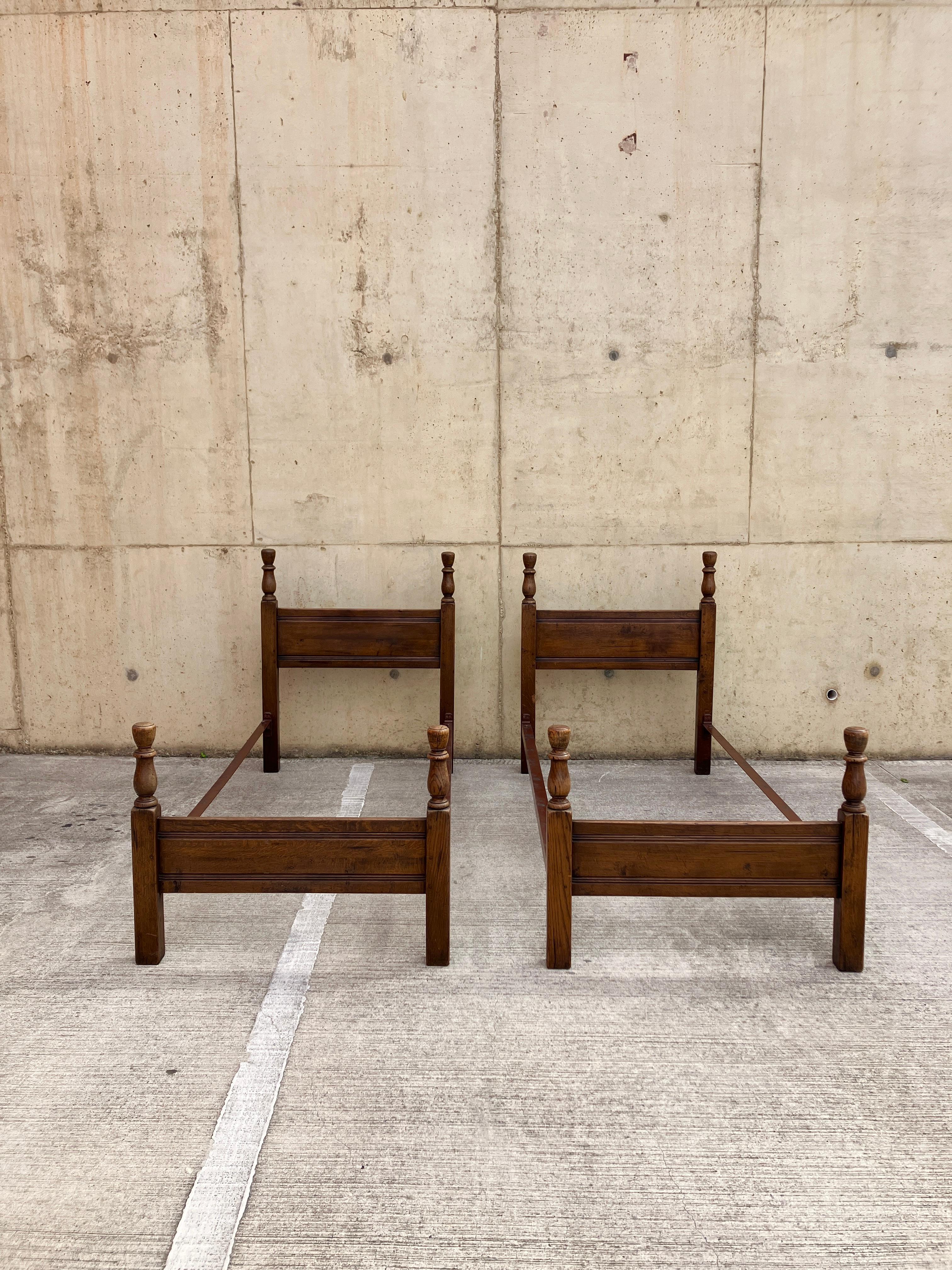 A lovely pair of solid oak bed frames from the early 20th century. The oak has a great colour and patina. Beautifully made, solid constraction, easy to put together with metal sides and bolts. 

Great condition for age with normal signs of