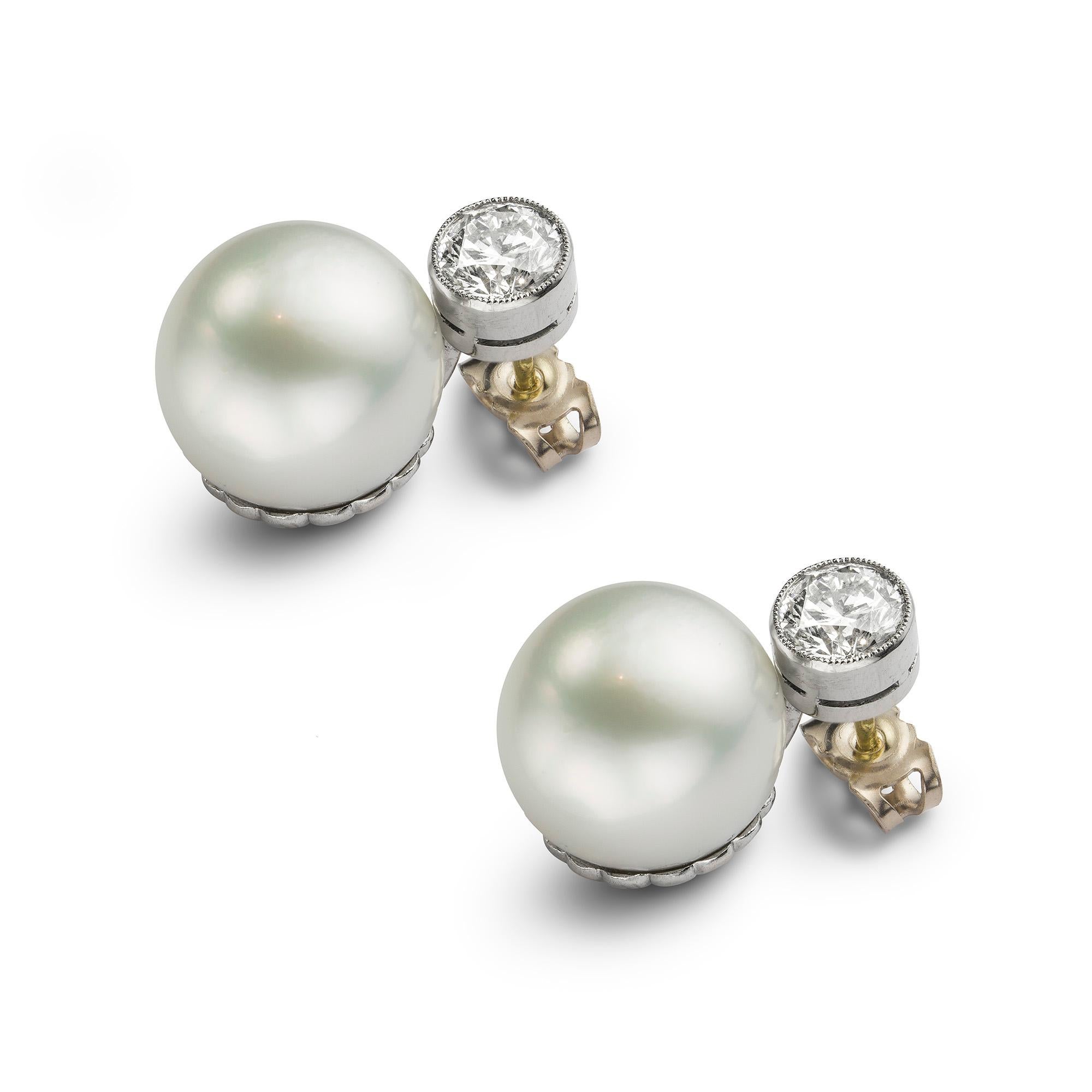 A pair of South Sea cultured pearl and diamond earrings, each earring with a single old brilliangt-cut diamond top, the one diamond weighing 0.90 carats and the other 0.91 carats, assessed to be of I-J colour and SI2-I1 clarity, each millegrain-set