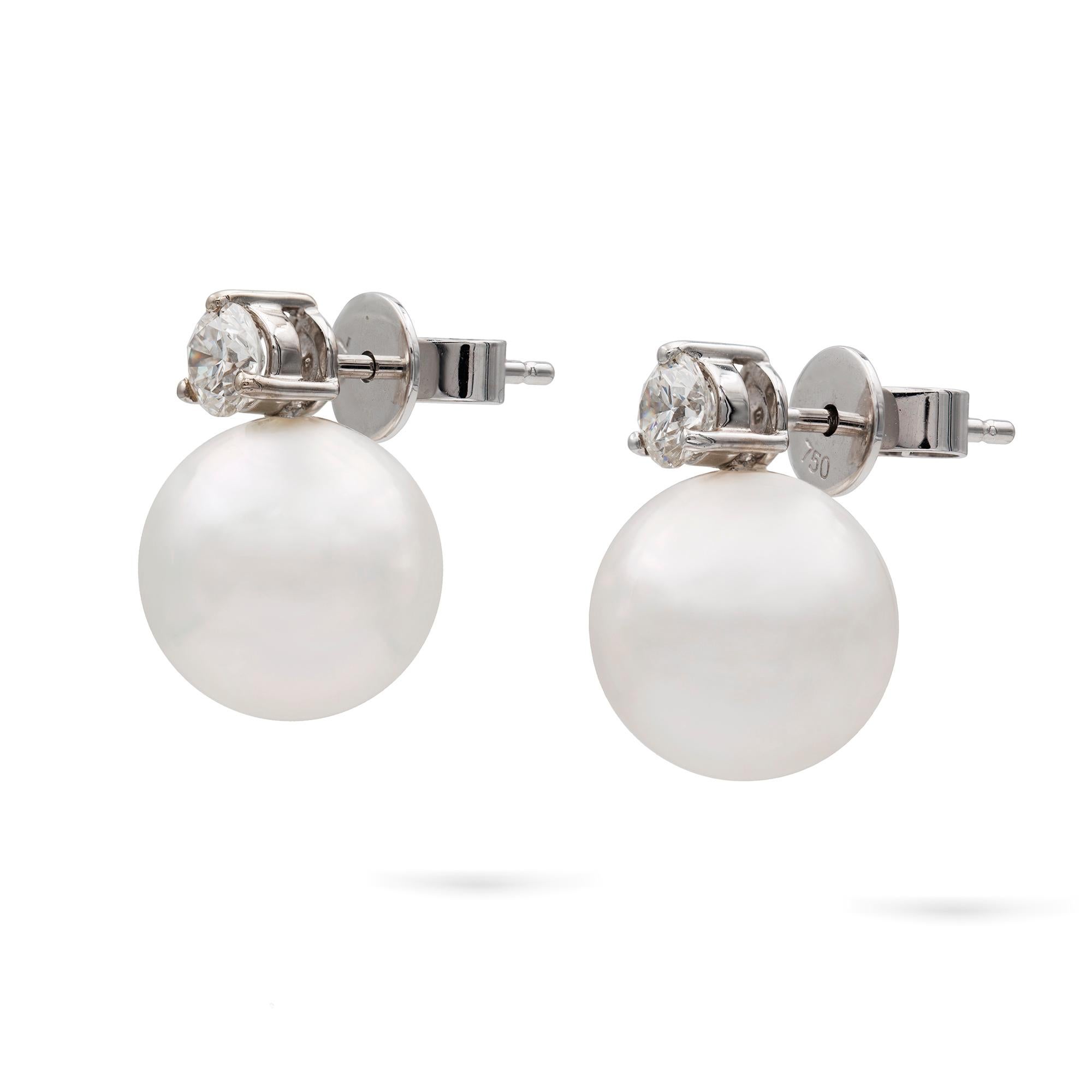 A pair of South Sea cultured pearl and diamond stud earrings, each earring consisting of a round pearl, approximately 11.5 mm in diameter, attached to a three claw-set round brilliant cut diamond top, weighing 0.56 carats in total, assessed colour
