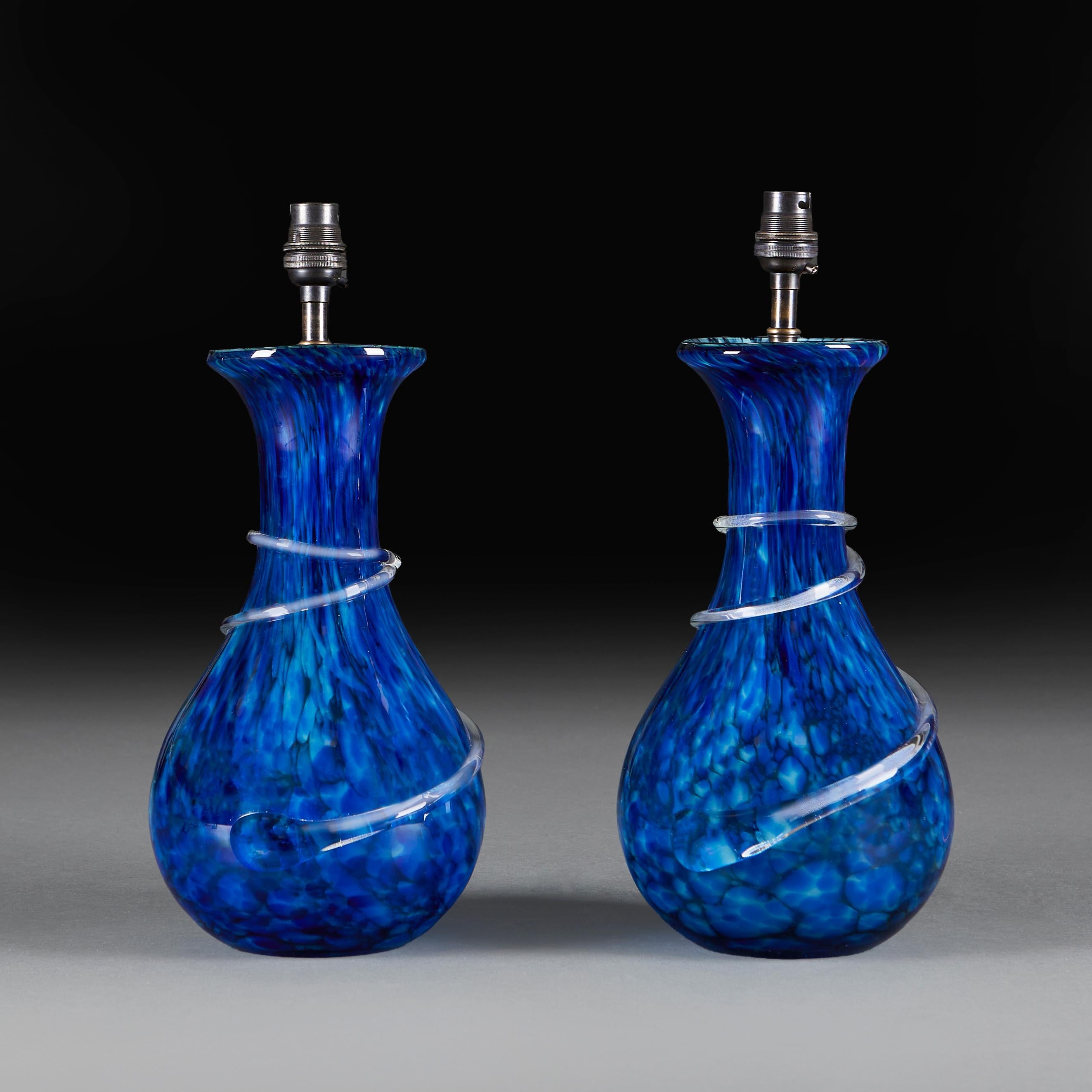 A pair of mid century Murano mottle blue glass vases, with flared rims and applied glass spiral to the necks, now mounted as lamps.

Please note:

Lampshade not included. Lamp photographed with a 16” diameter pale cream card Pembroke