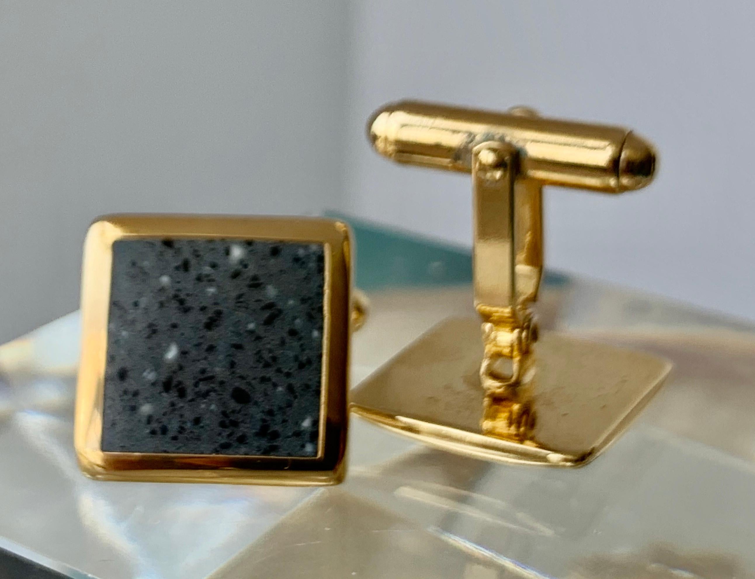 A pair of square shaped cufflinks with grey enamel speckled with black and white.  The frames are gold filled and have 