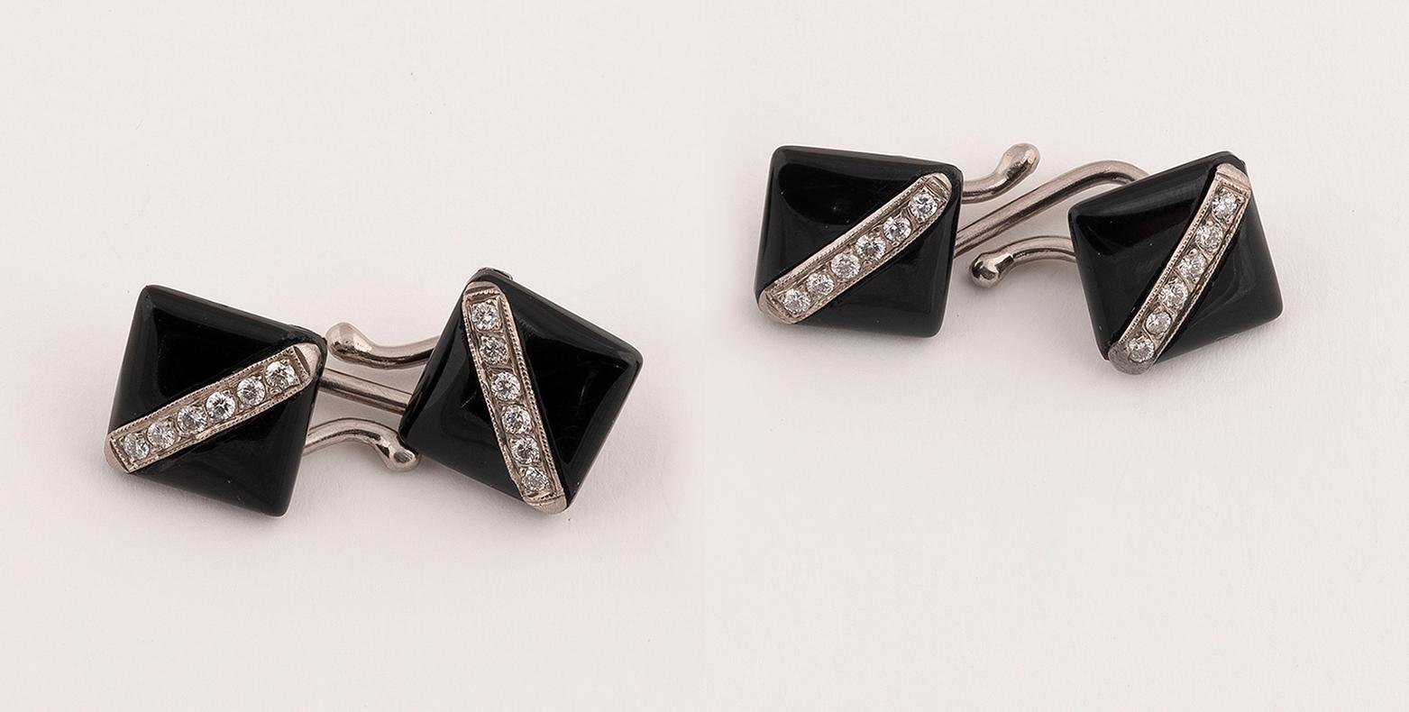 Double-sided, each of square form, set with row of diamonds, between polished onyx plaques.