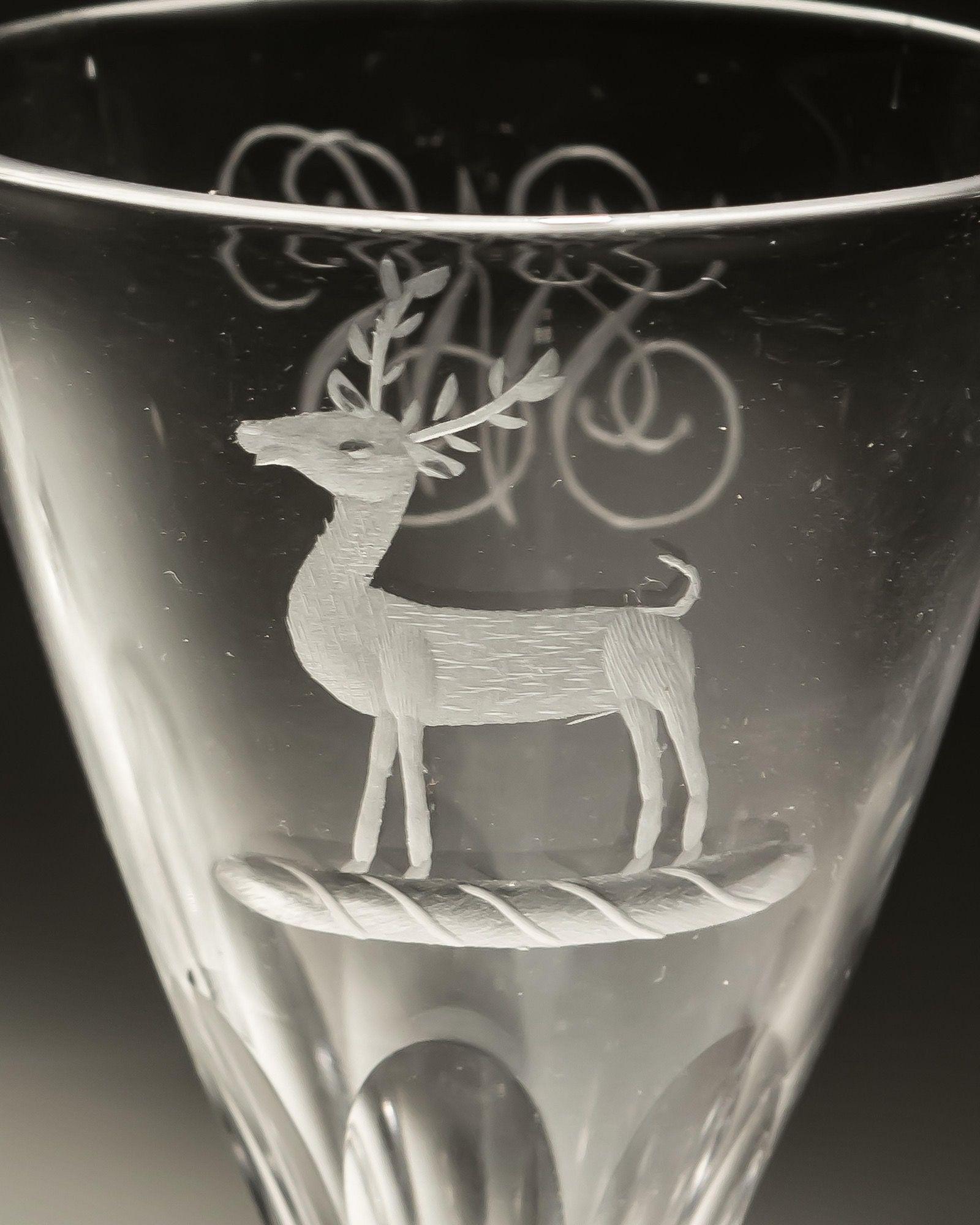 A pair of slice cut glasses engraved with stags and initials SWS on reverse.