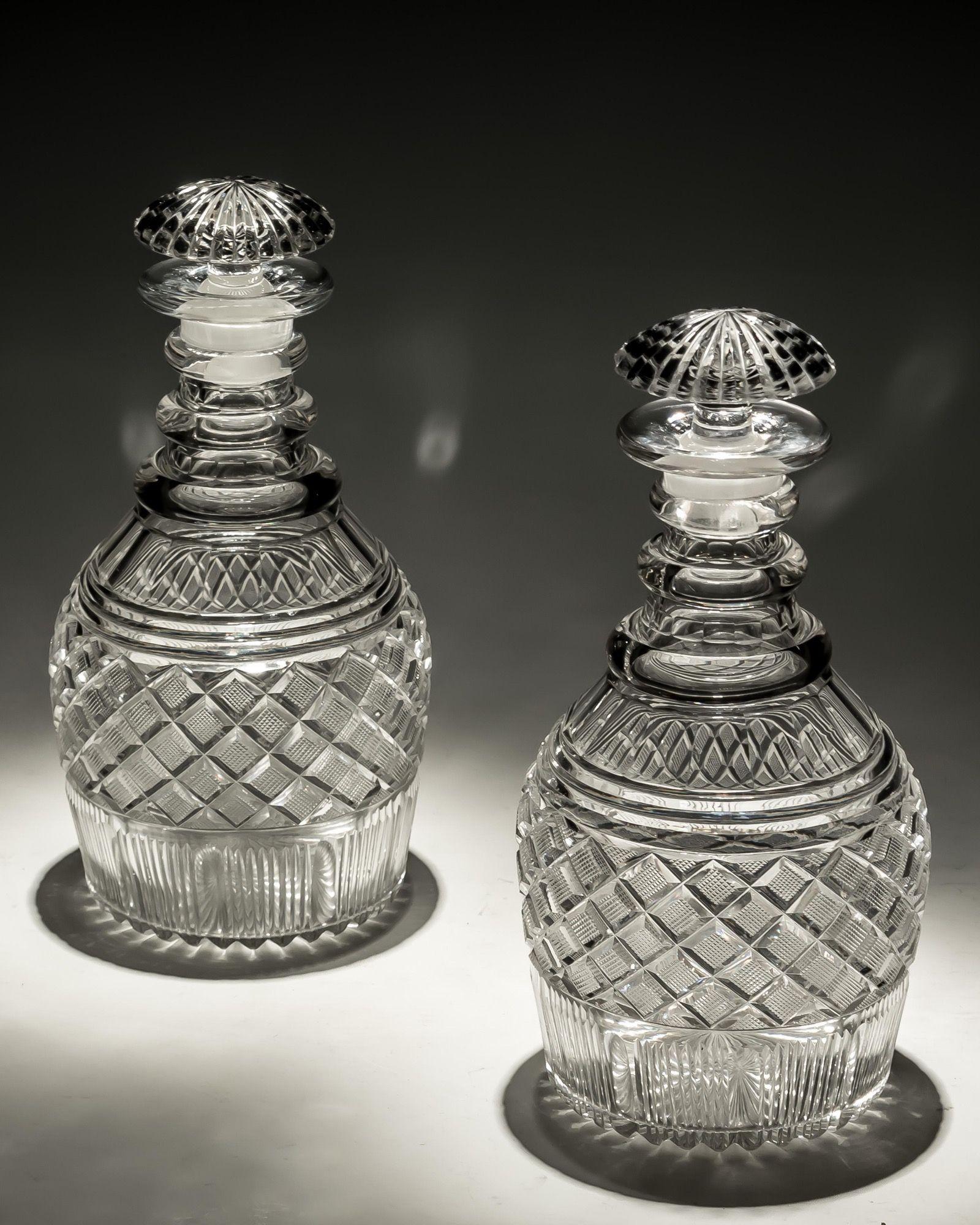 A pair of strawberry diamond cut Georgian decanters with mushroom stoppers.