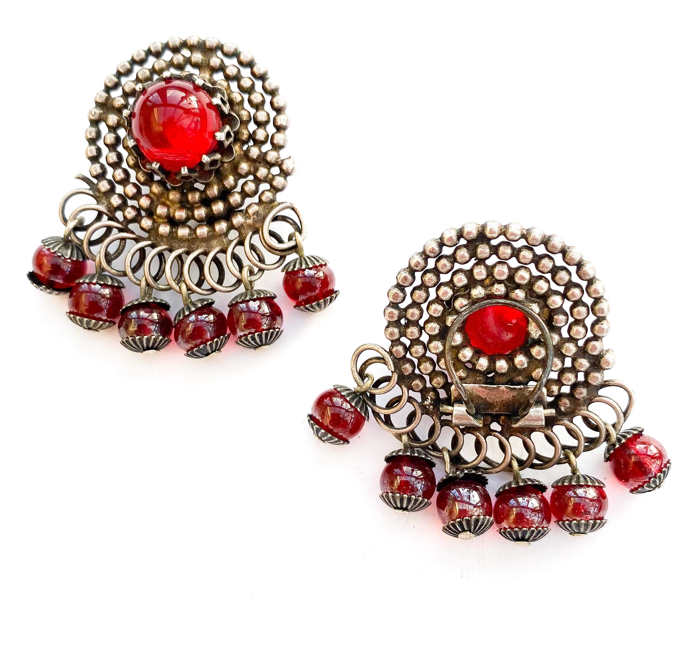 Par de pendientes estilizados de metal plateado y vidrio rojo en forma de 
