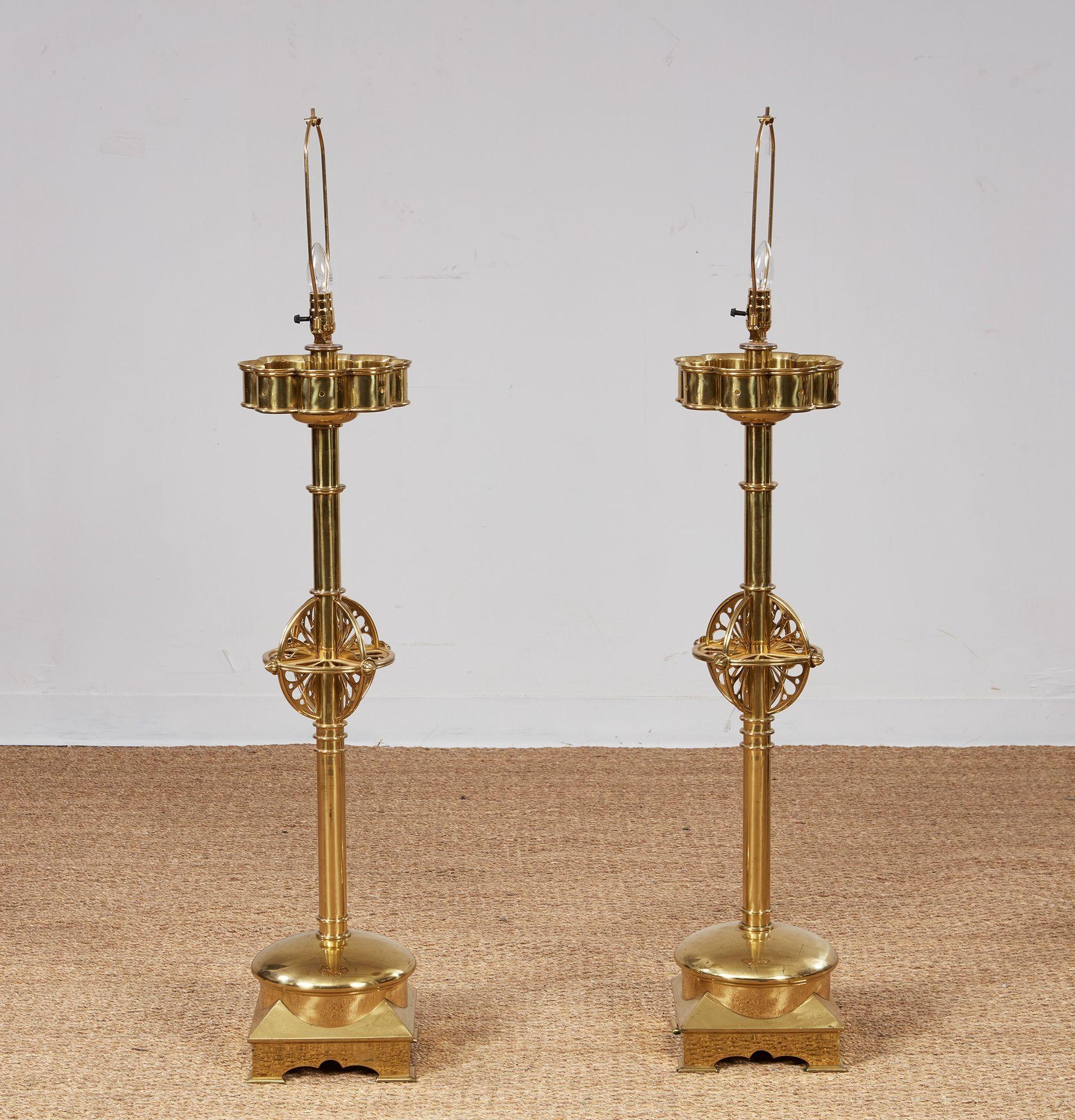Paire de lampes de table de grande qualité, avec des colonnes en laiton qui se distinguent par des éléments décoratifs, notamment des sommets crénelés, des sphères armillaires ajourées et des bases incurvées au-dessus de socles avec des pieds en