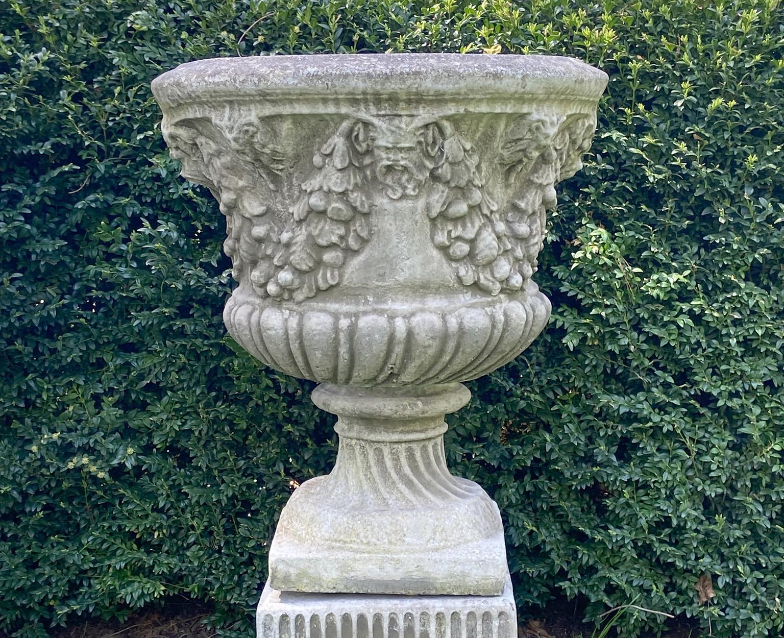 Cast Pair of Swag and Mask Composition Stone Urns on Decorative Pedestals
