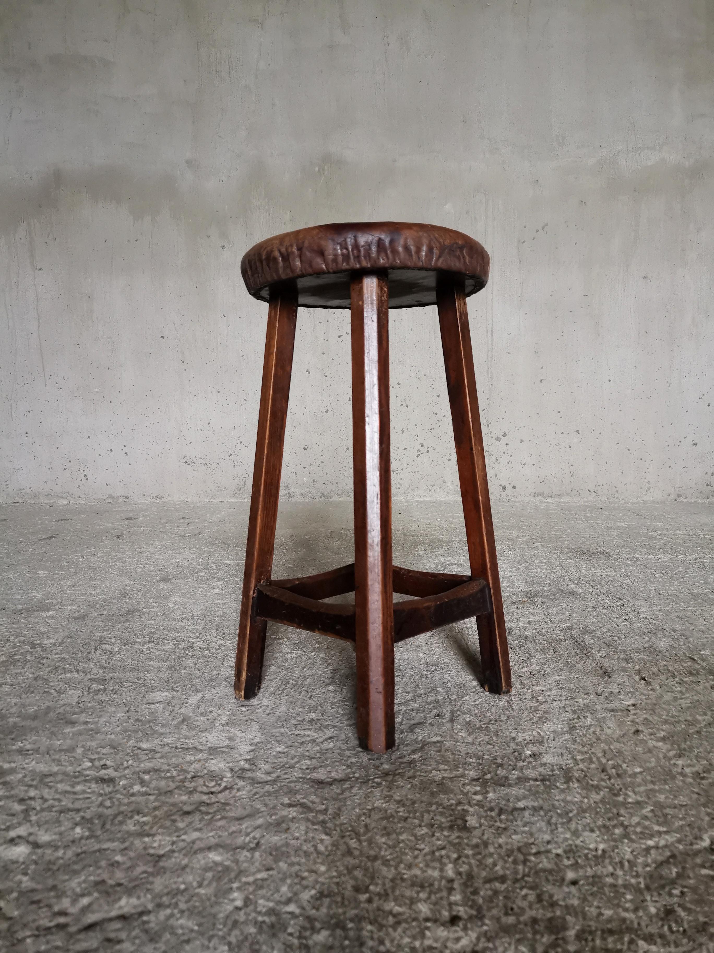 A stunning pair of Swedish 1930-40s workshop stools in solid pine. 
Thick, smooth and intact leather seats with a refined lustre. Seats meticulously mounted with an string of tiny nails. 
Well crafted traditional joinery work of dark patina wood
