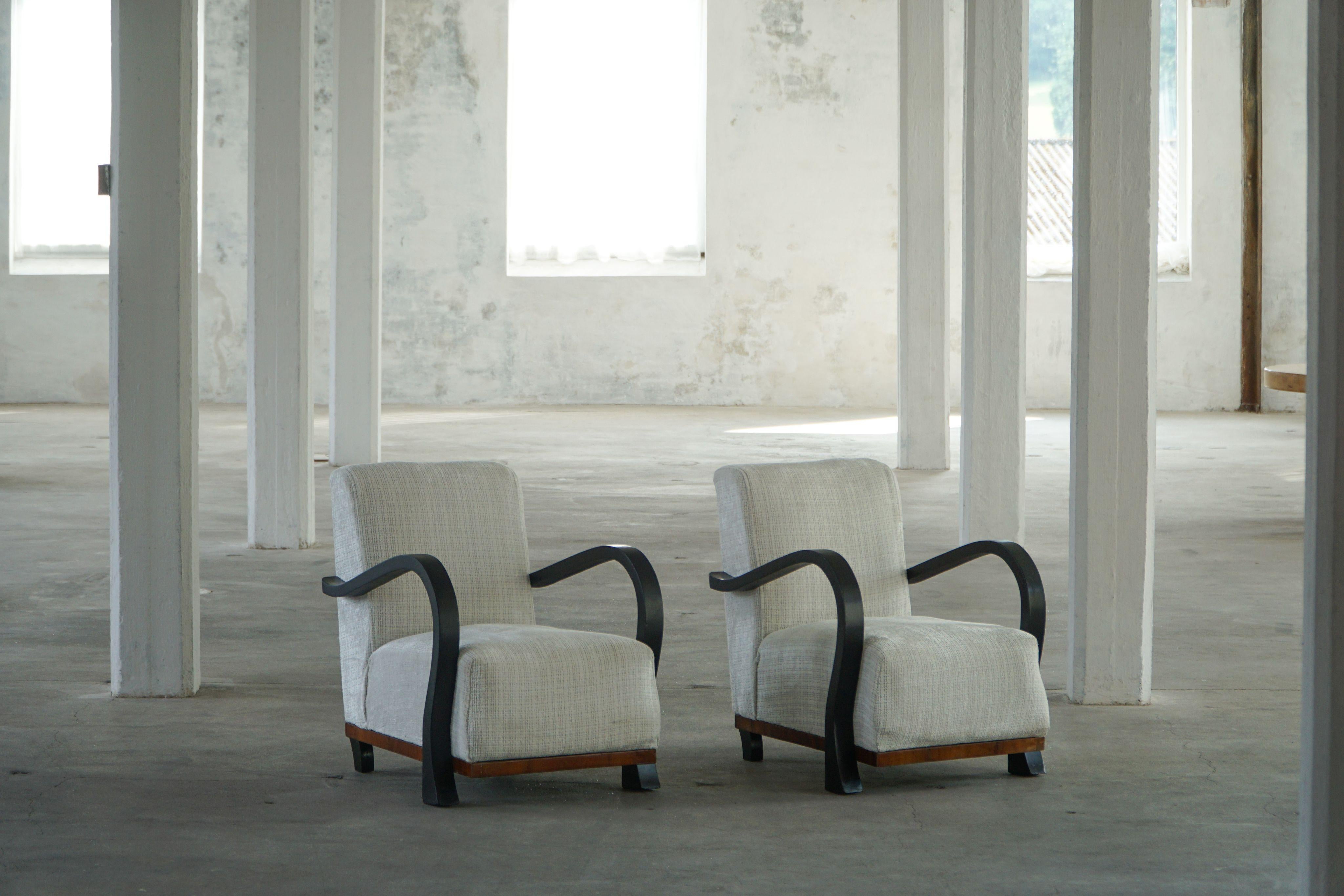 An exquisite pair of Swedish lounge chairs from the Art Deco period, likely dating to the 1930s–1940s, characterized by their bold, sculptural bentwood arms that elegantly flow into the legs. Crafted with a minimalist yet expressive form, these