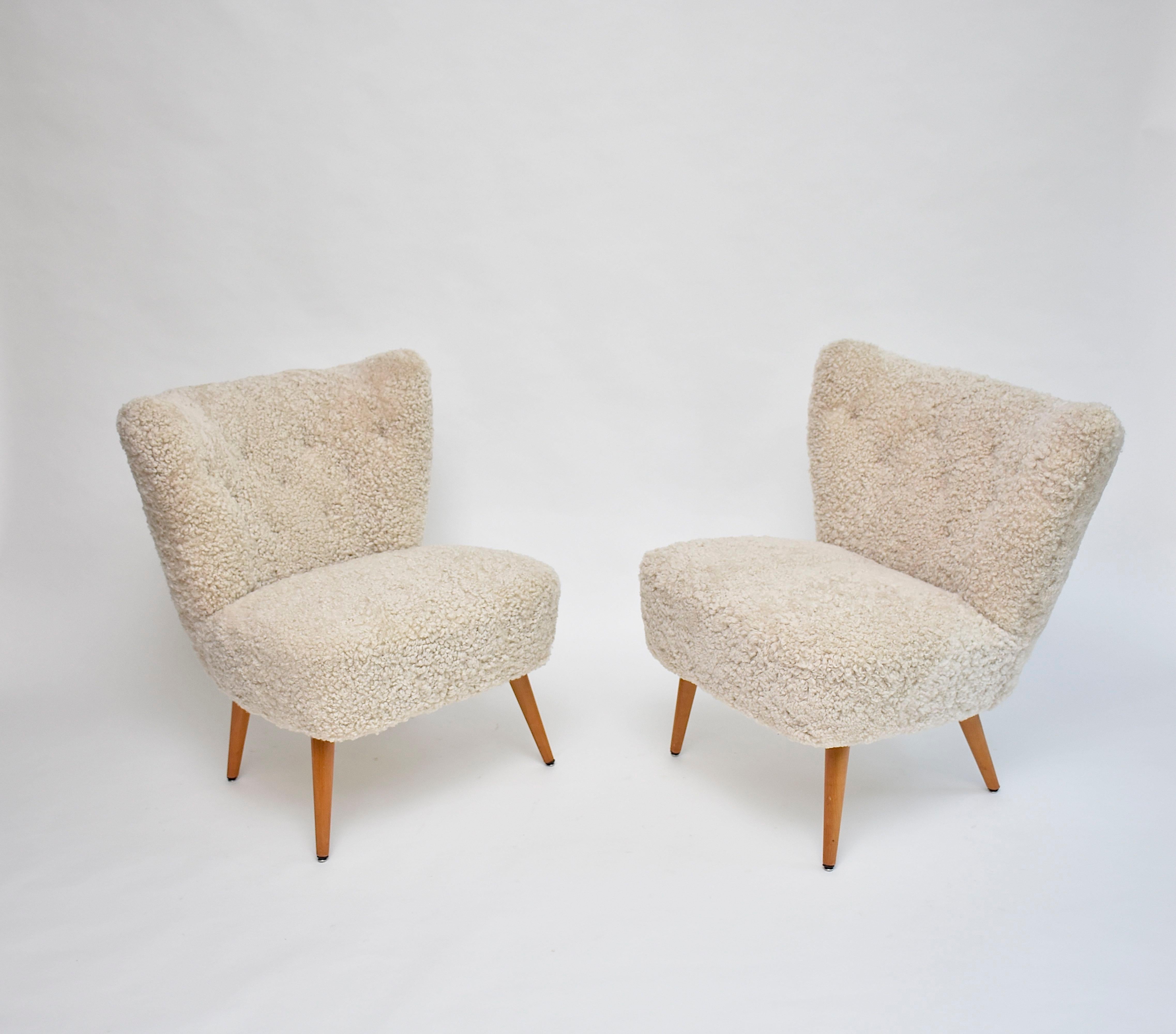 An amazing pair of Scandinavian design cocktail or lounge chairs/ fauteuils.
The chairs have a unique look and elegant shape.
With elegant beech legs. 
New soft sheepskin upholstery and comfortable seating.
Period- ca. 1940
Place of origin- Sweden