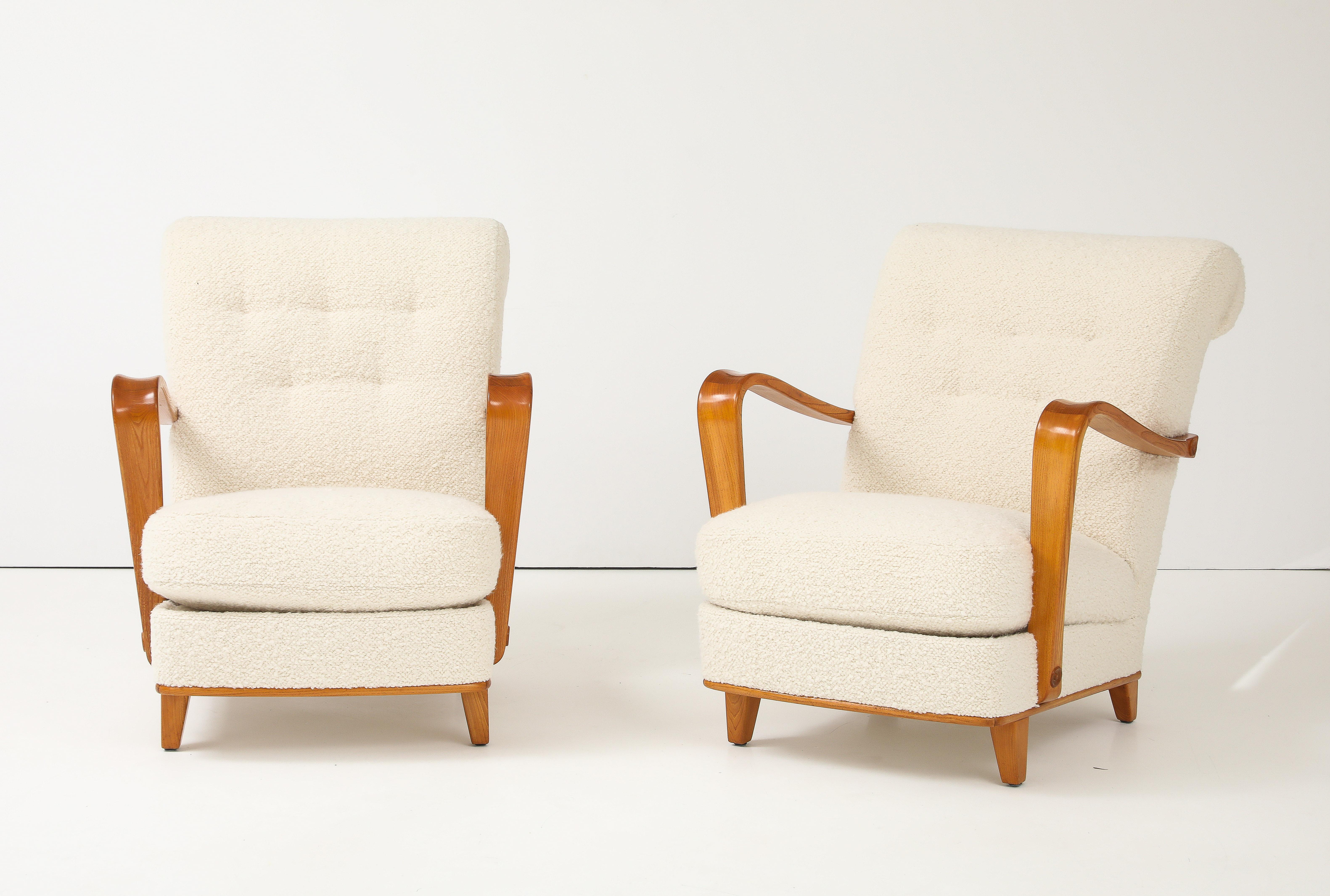 A sculptural pair of Swedish Modern elmwood and upholstered open-armchairs, Circa 1940s, each with a generous scrolled backrest, high sloped armrests with rondels, drop in cushion seat raised on square tapered feet. New upholstery. Cushions sit high