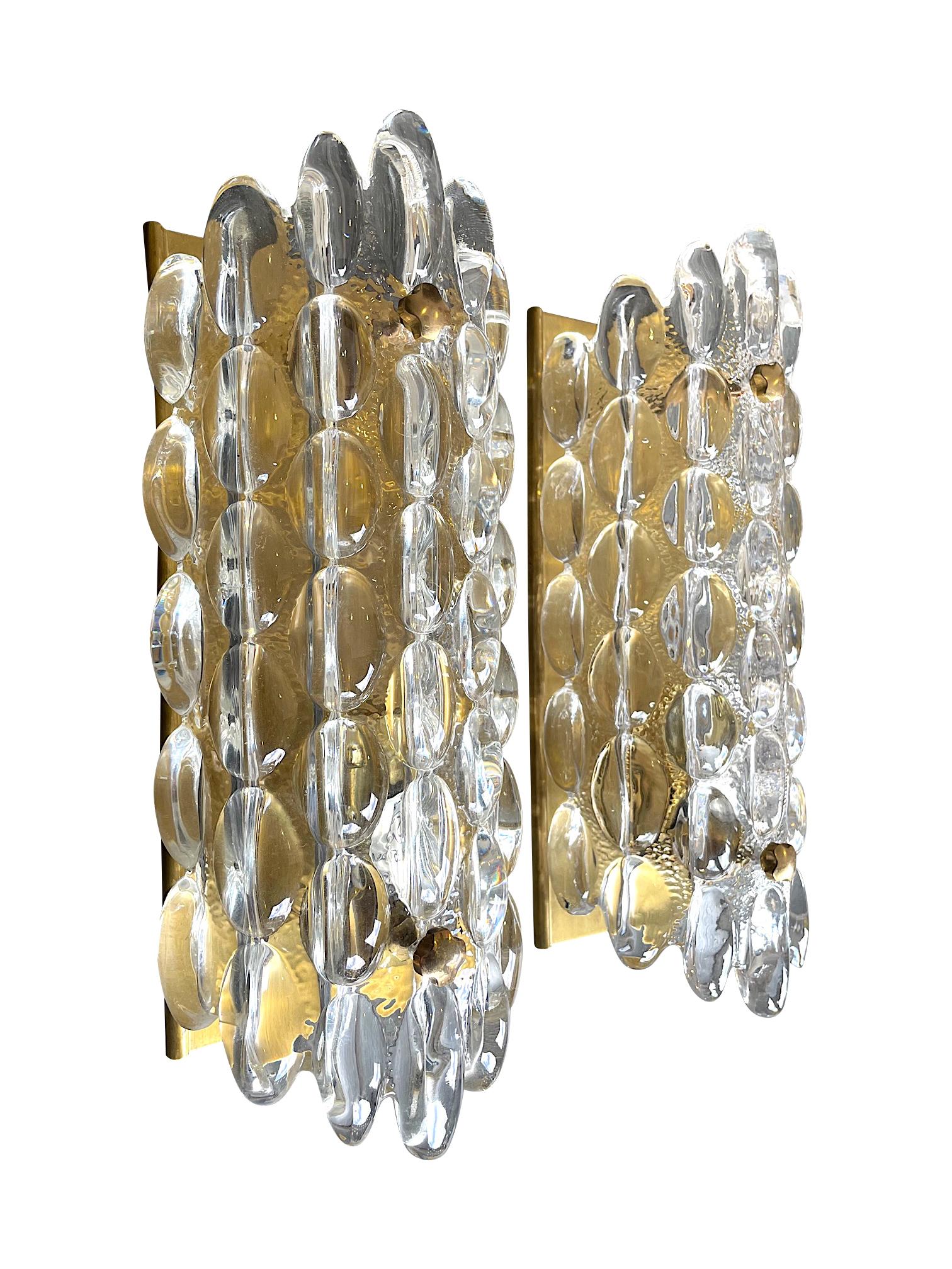 A pair of 1960s Swedish Orrefors glass wall sconces by Carl Fagerlund for lighting company Lyfa, on brass plates with brass flower shaped screw fixing. Re wired with new brass fittings and PAT tested.