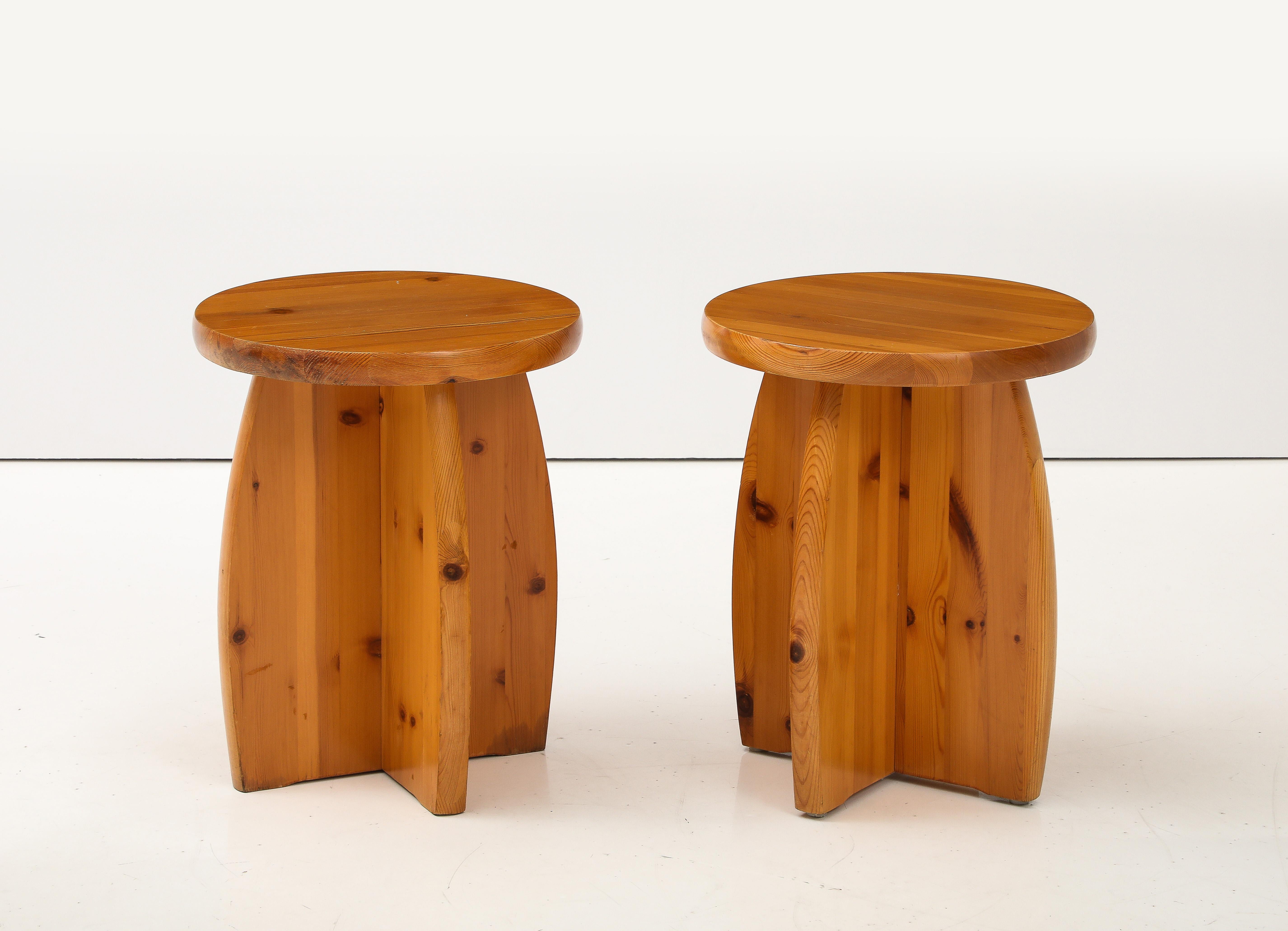 A pair of Swedish pine side table or stools, Circa 1970s, with a solid round pine top raised on four solid curved supports.