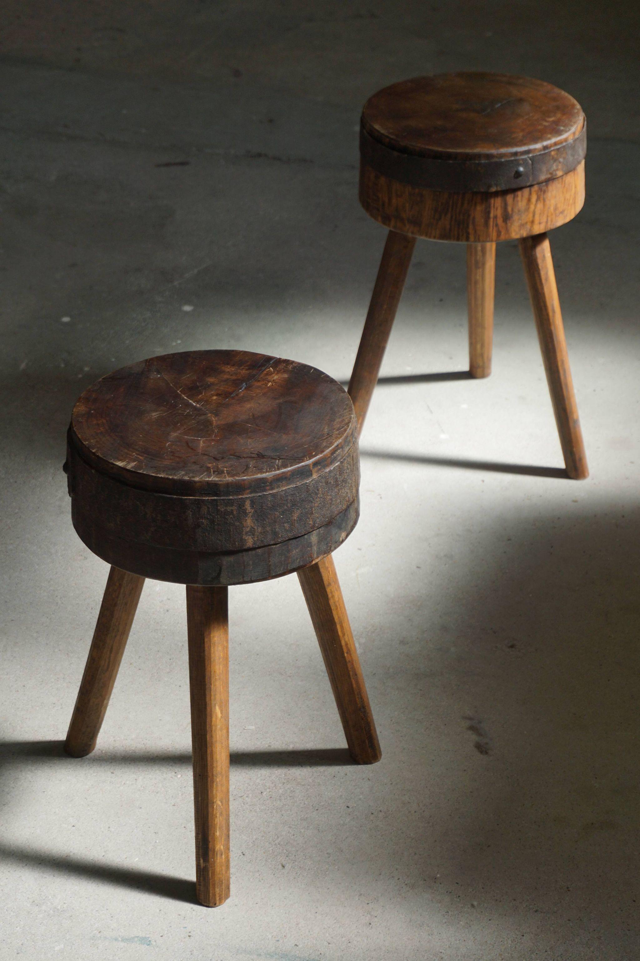 A pair of Swedish stools in solid wood with an iron fitting, early 20th century. 

- Brutalist, rustic design.