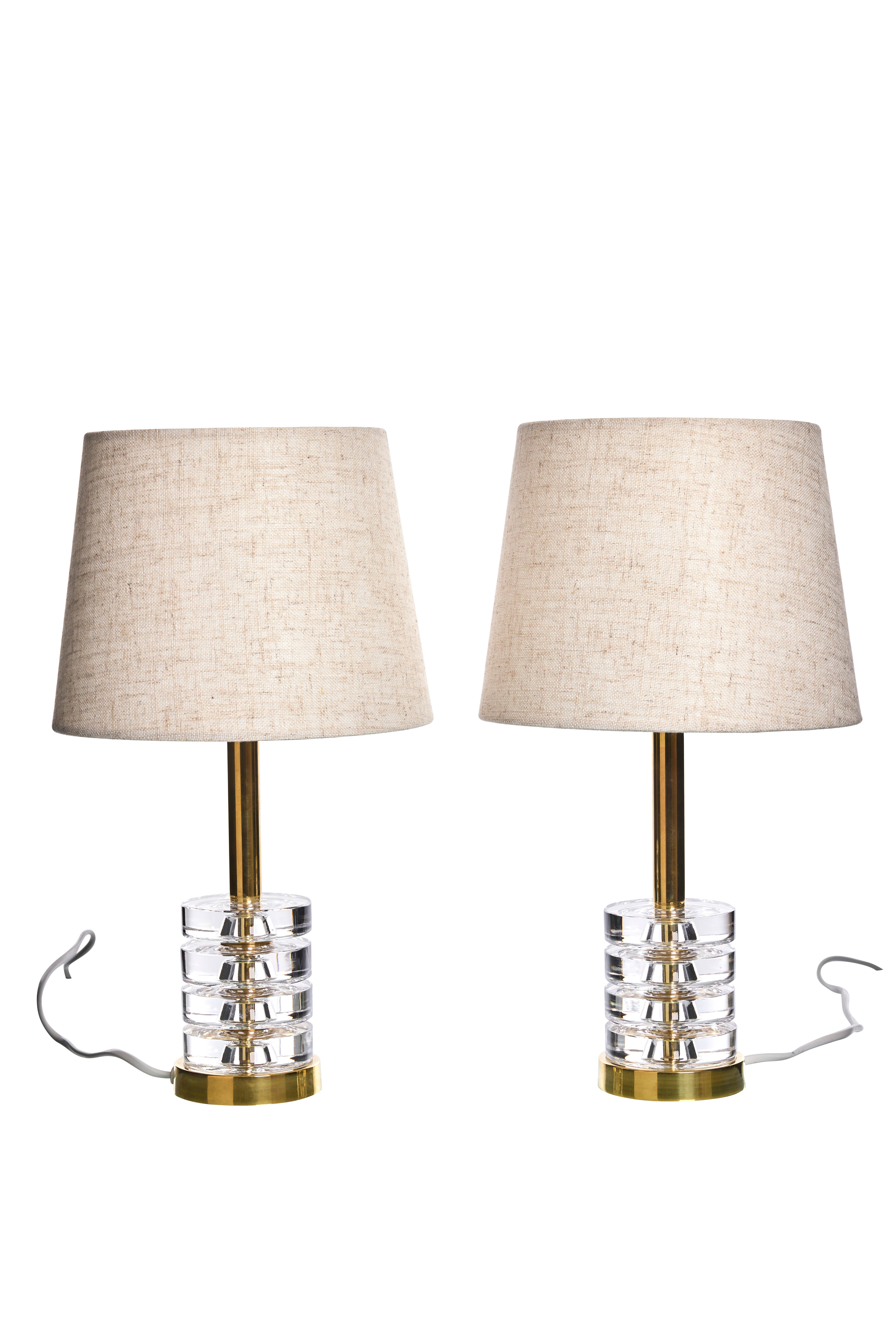 Paire d'élégantes lampes de table de Carl Fagerlund pour Orrefors. Le beau design des lampes leur permet de s'adapter à tous les styles d'intérieur.
Les lampes sont composées de quatre disques en verre de cristal clair, séparés par des disques en
