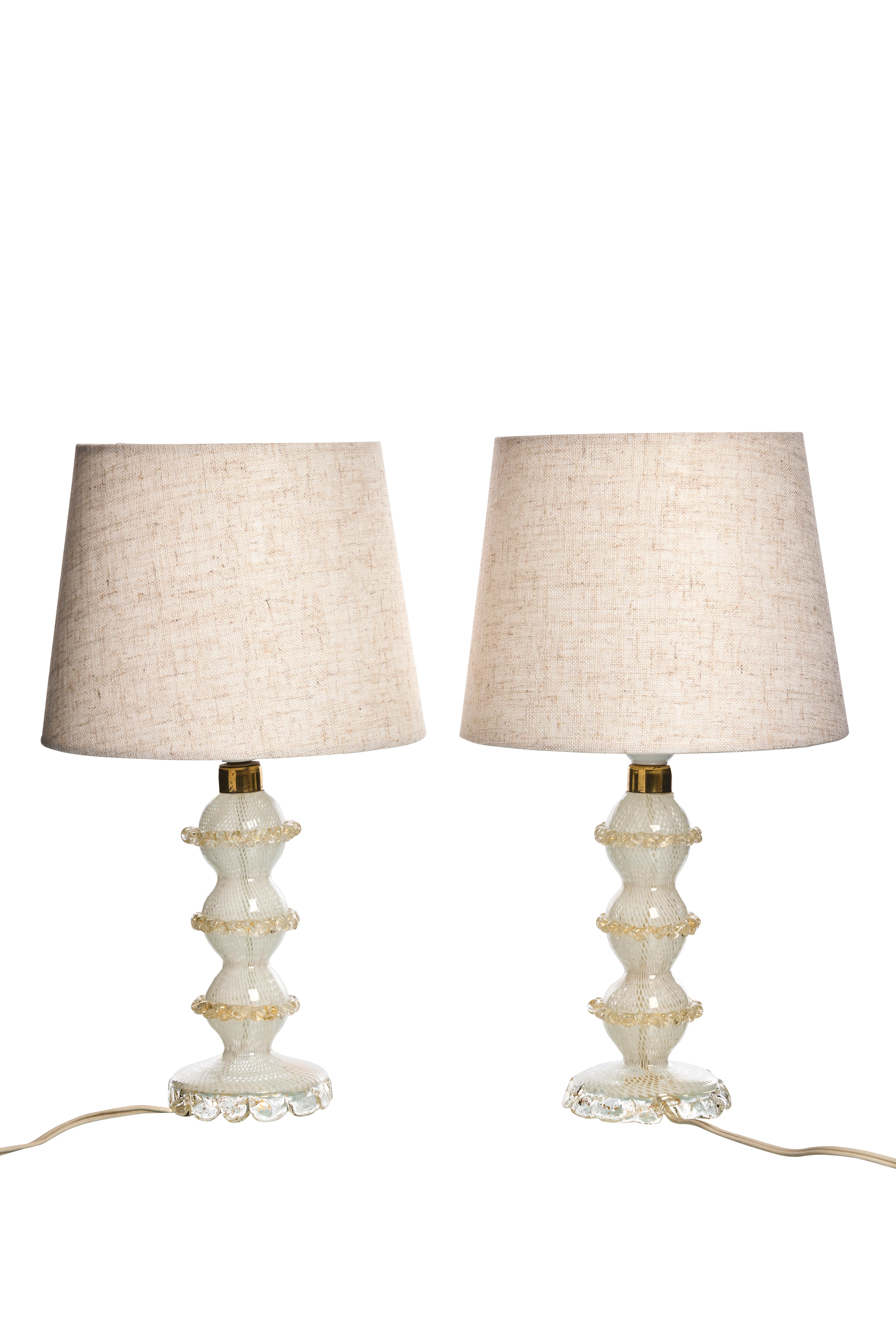Ces étonnantes lampes de table du milieu du siècle sont fabriquées en verre de Murano et décorées avec de l'or 24k. Le design complexe en verre présente un motif ondulé dans la masse de verre et un motif texturé sur la base de la lampe.

Veuillez