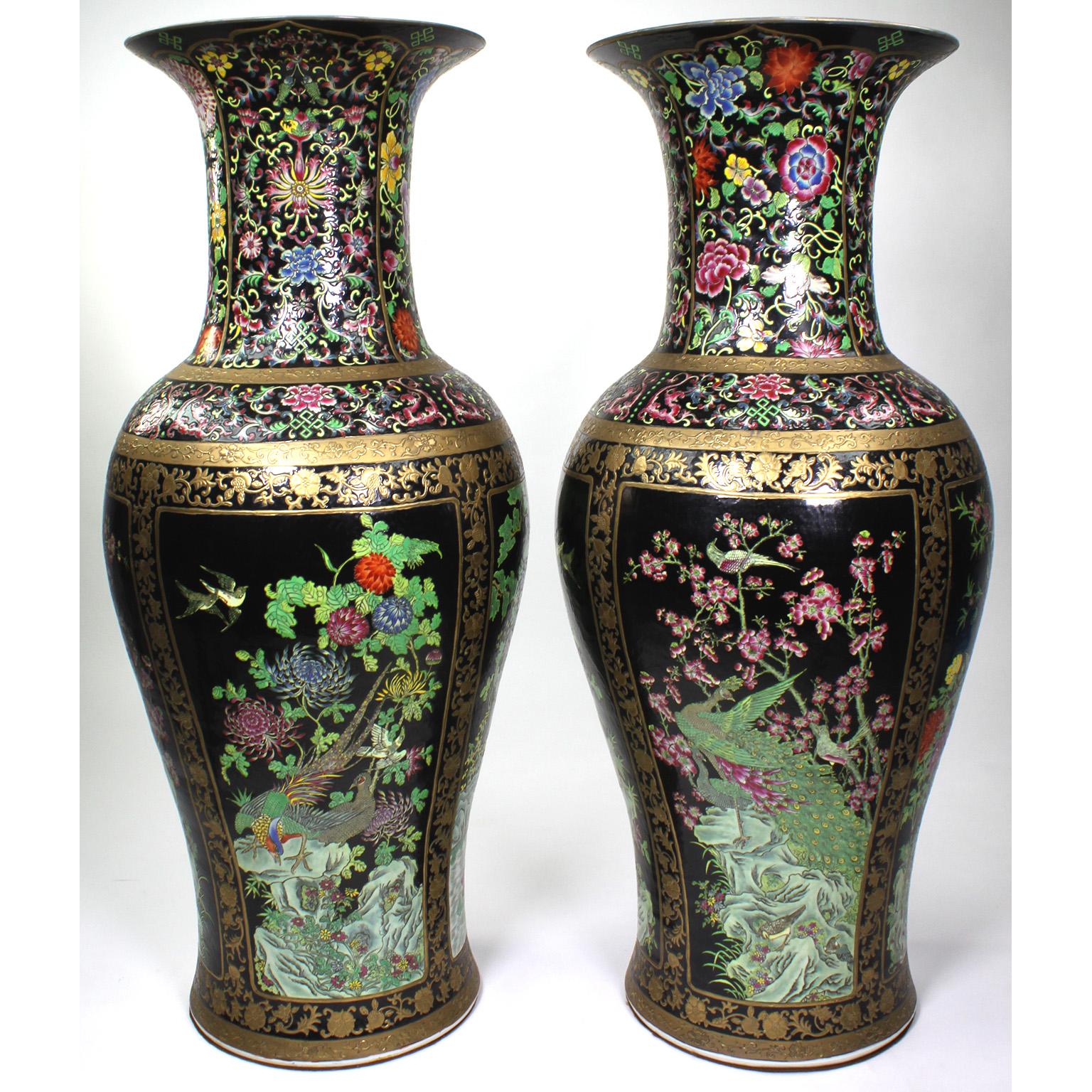 Ein Paar große figurale Vasen aus chinesischem Exportporzellan. Die eiförmigen Porzellankörper sind mit farbenfrohen Blumen, tropischen Vögeln, Bäumen, Lilien und einem Teich verziert, mit einem paketvergoldeten Rand und schwarzem Hintergrund.
