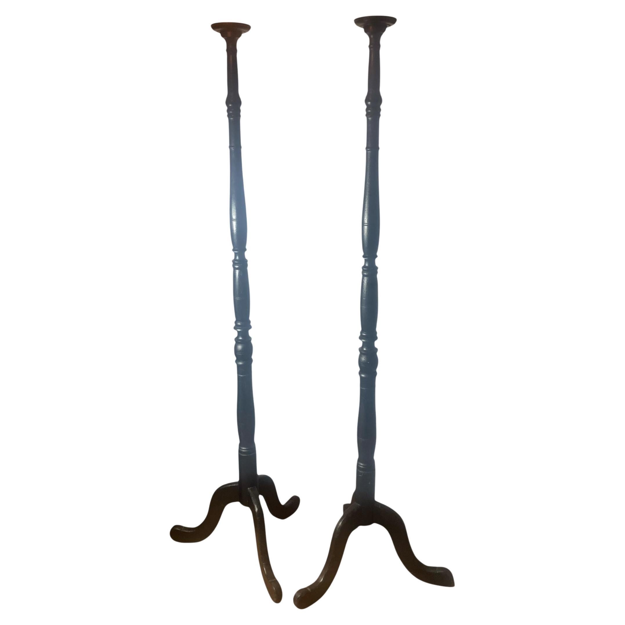Un par de antorchas altas de tres patas ebonizadas en venta