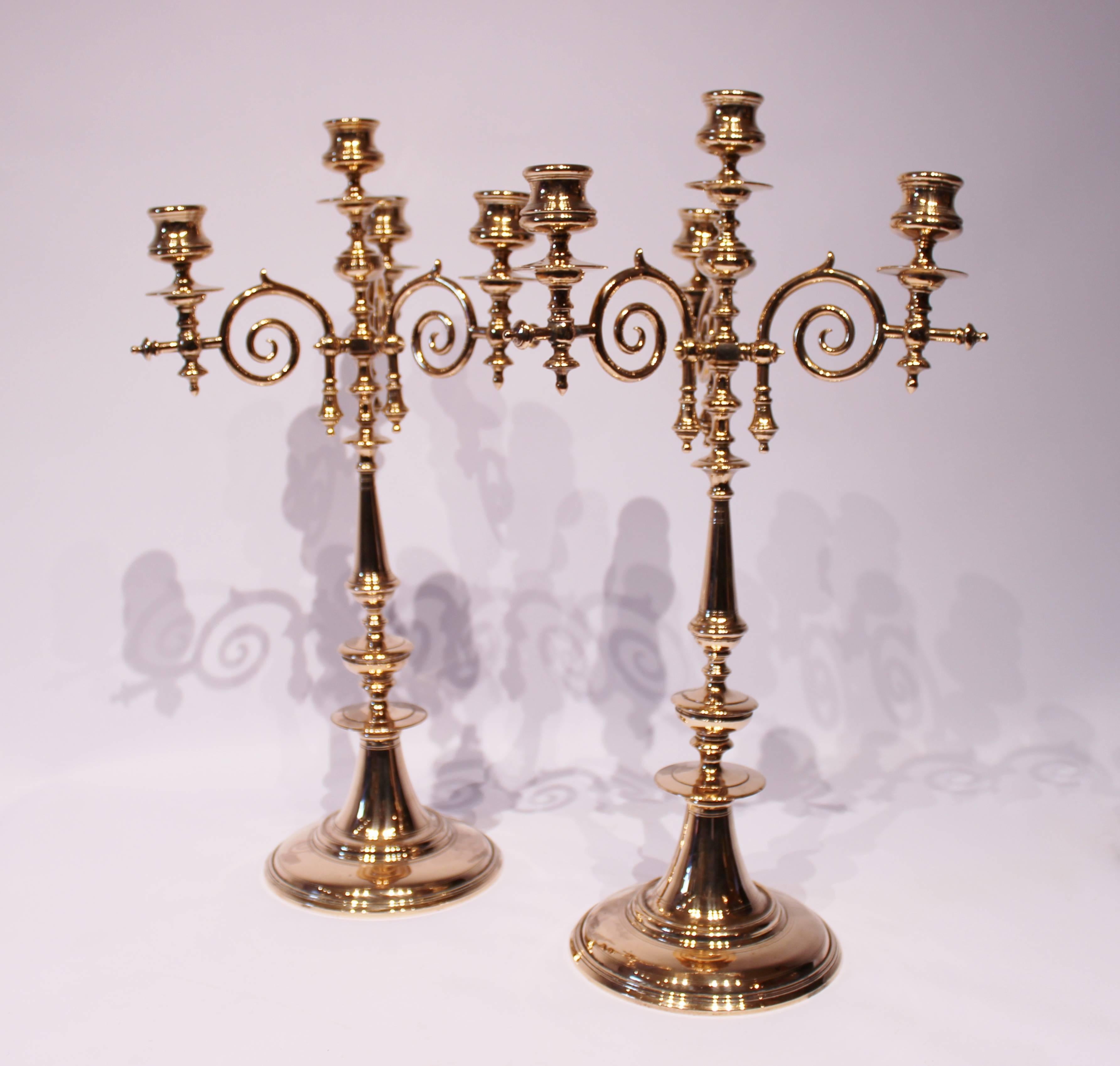 A pair of tall four-armed brass candlesticks, in great vintage condition from circa 1880s.