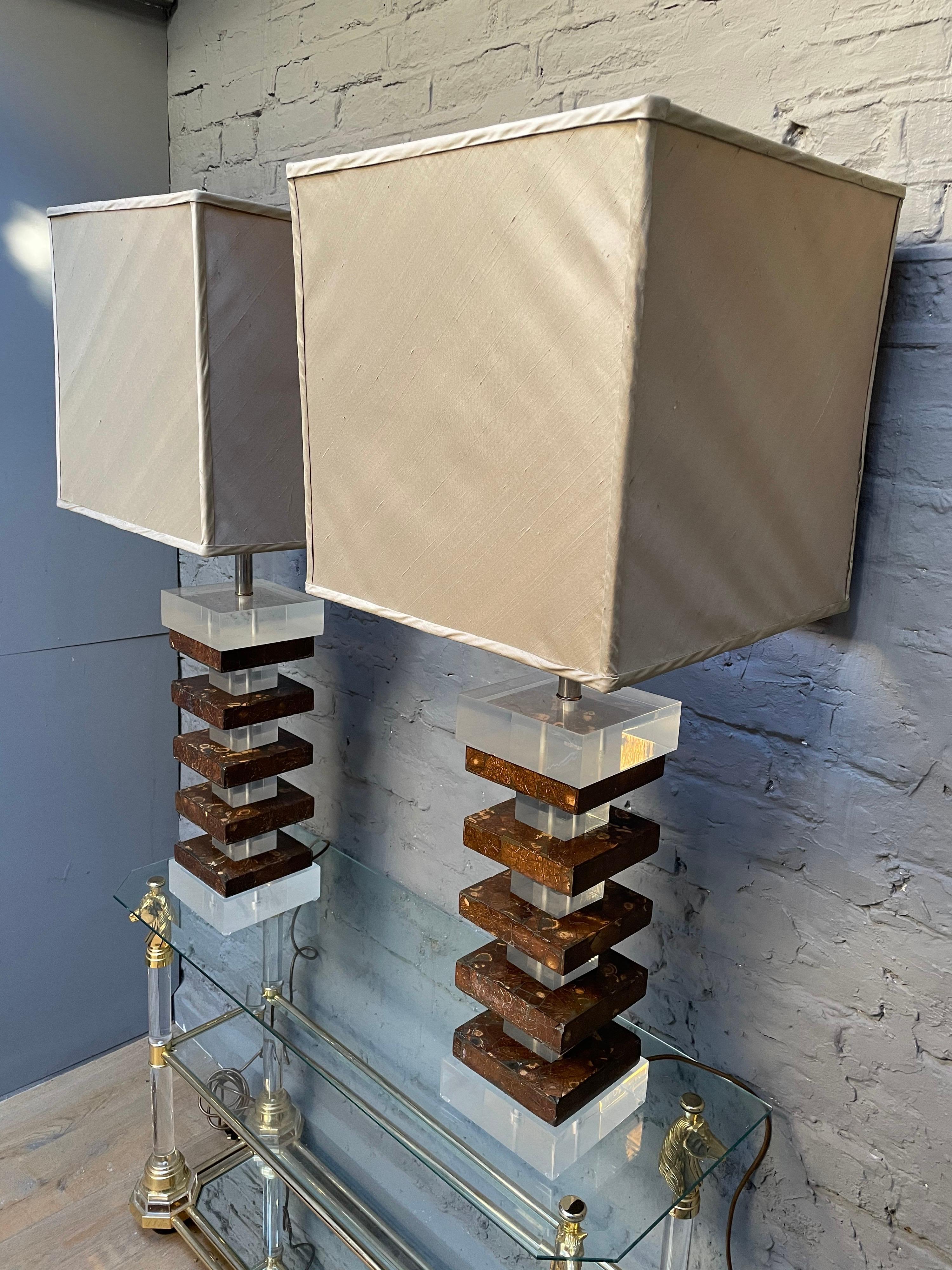 An oversized pair of large table lamps with handmade gold silk lampshades. The lamps of stacked blocks of Lucite and faux tortoise shell. 

Dimensions given with shade included.