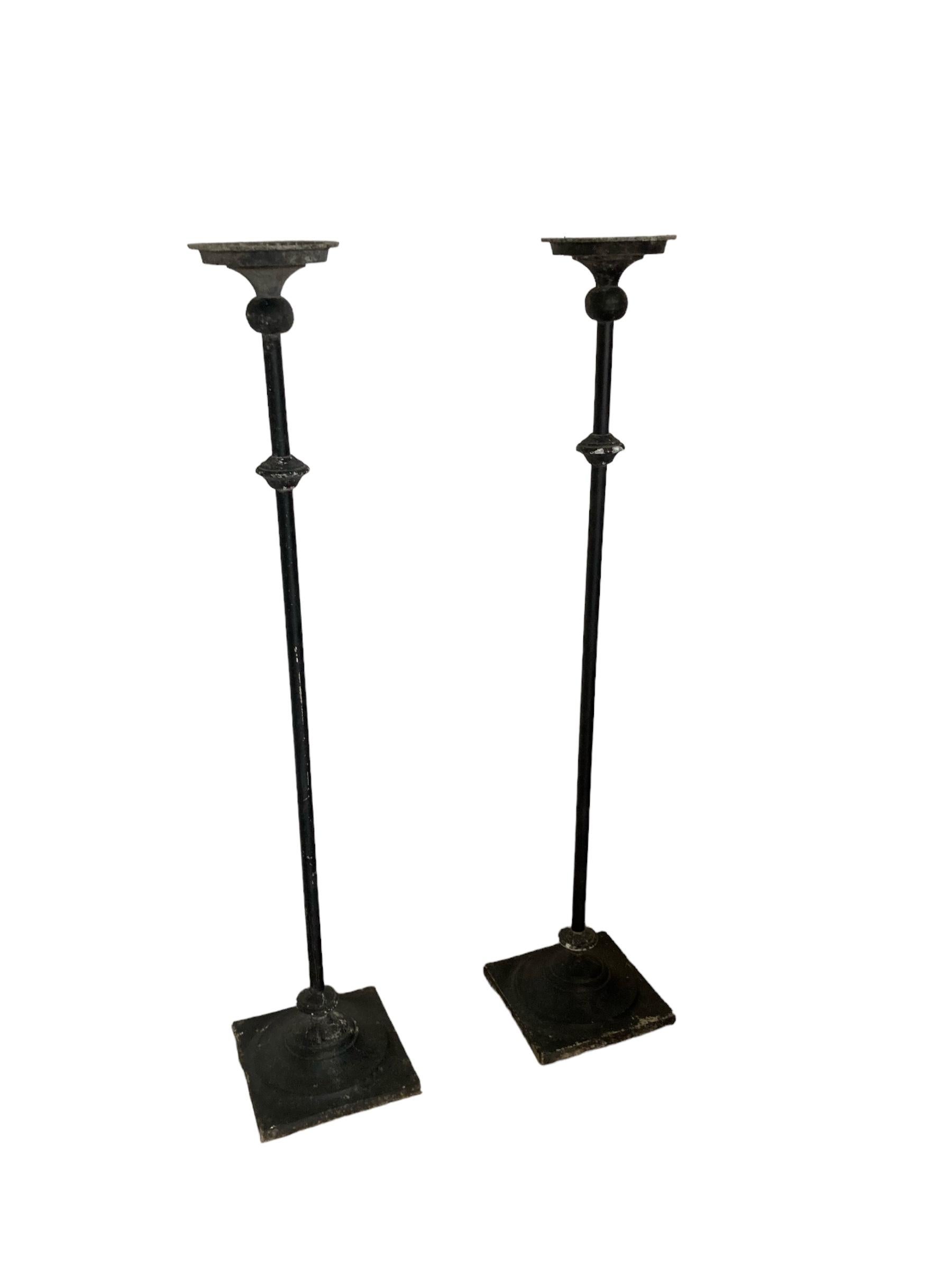 A Pair of Tall Wrought Iron Church Floor Candle Holders Gothic Style in original condition. Heavy square bases large top holders to stand large church candles. Perfect for a grand hallway or in a lounge, dining room would look great either side of a