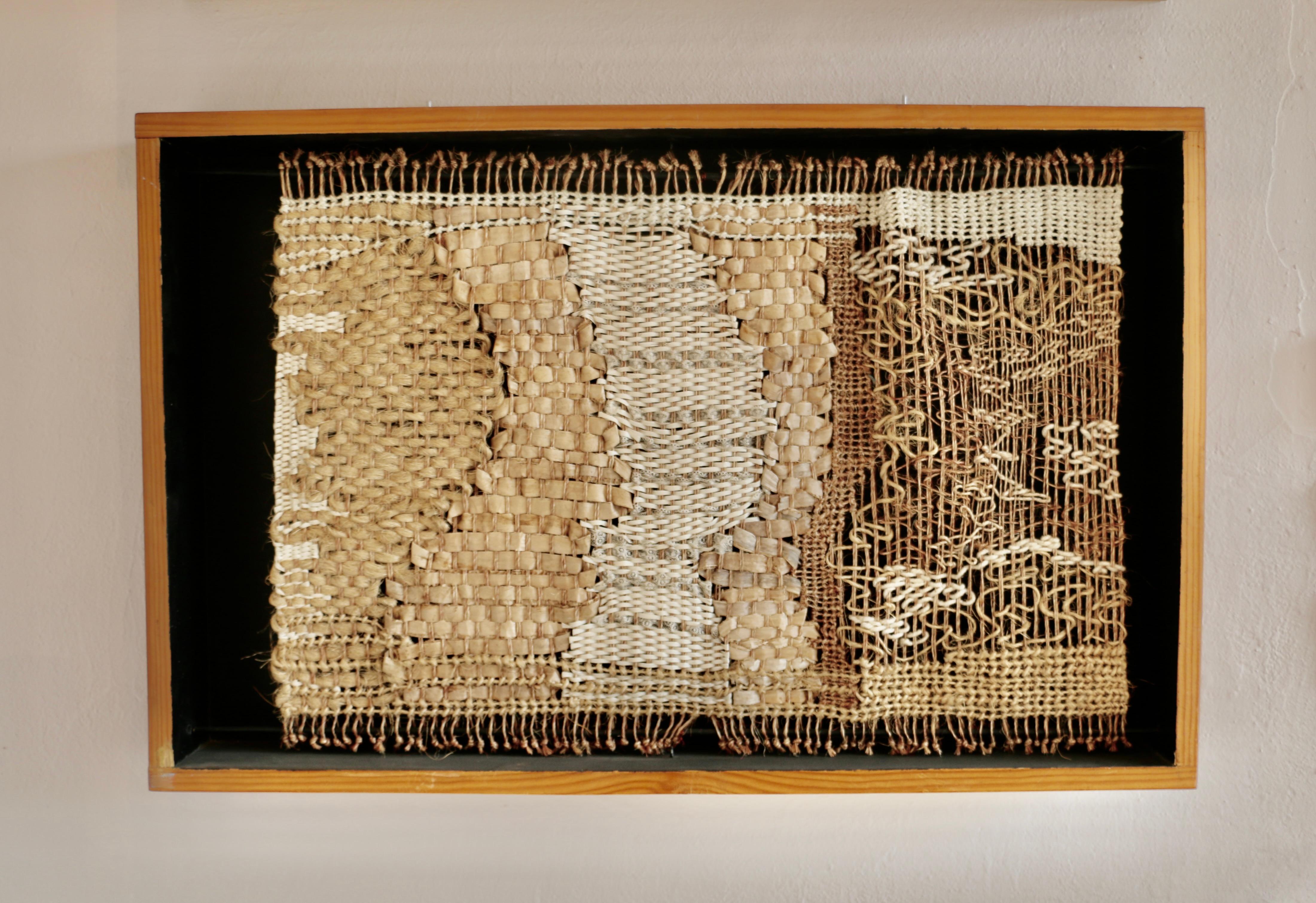 A pair of tapestries in natural materials installed in wooden boxes. Signature Laura Holguin 1990.