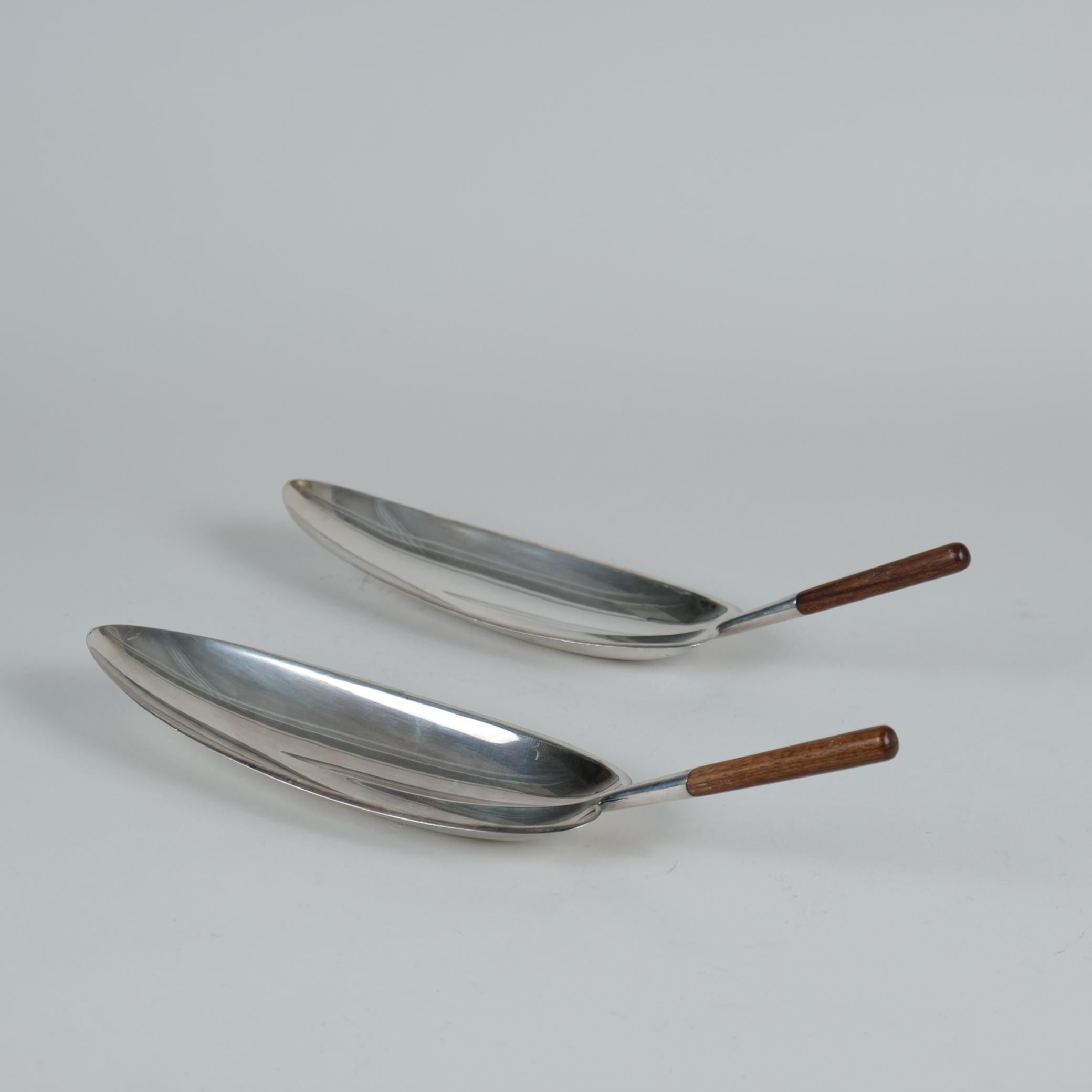 Una bellissima coppia di ciotole d'argento a forma di foglia con manici in teak, disegnate da Tapio Wirkkala e prodotte da Kultakeskus Oy in Finlandia negli anni Sessanta. Una perfetta dimostrazione di come Wirkkala integri la natura nei suoi