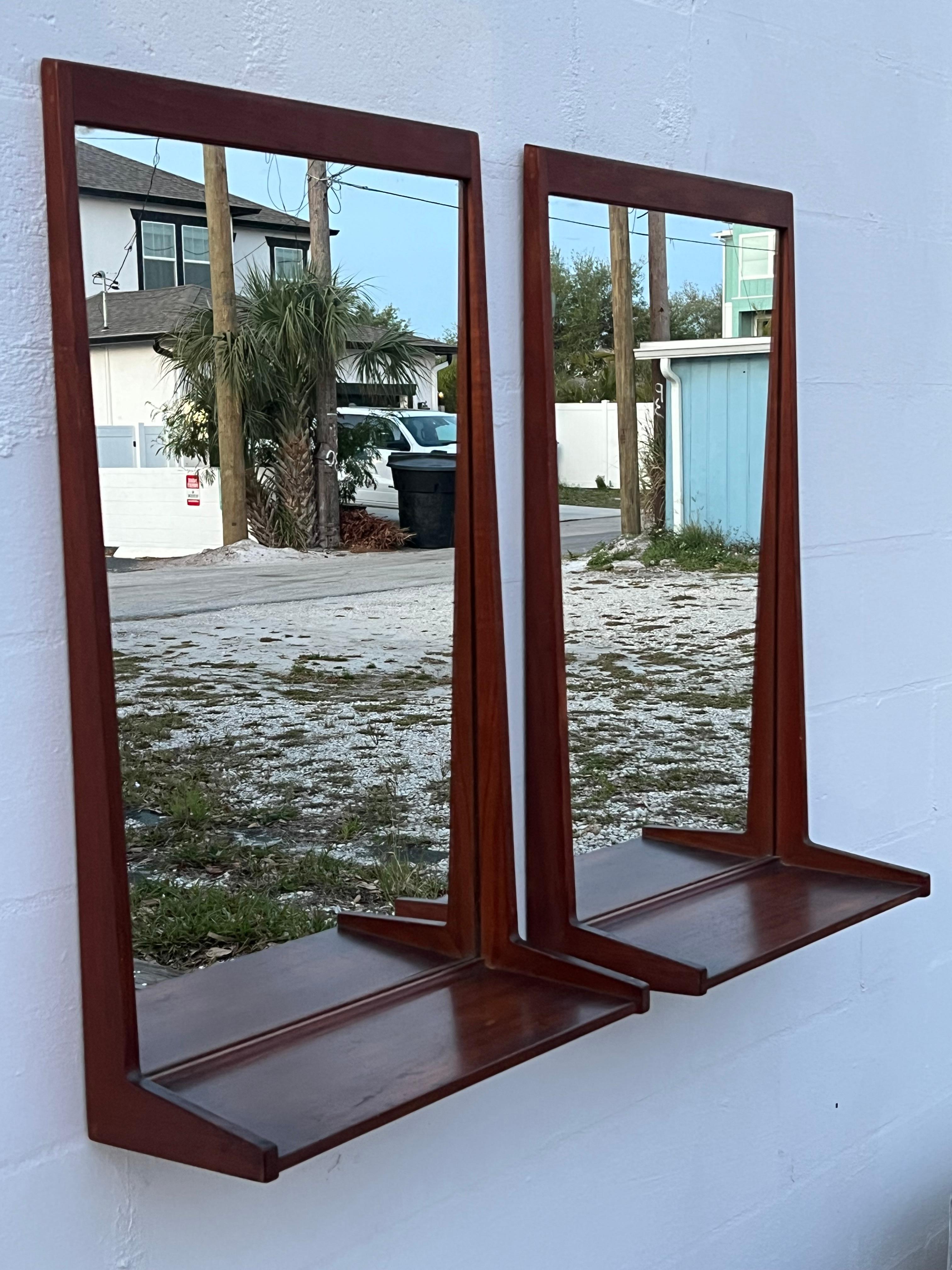 A pair of Danish modern, teak mirrors with shelves by Aksel Kjersgaard, Odder, model #180. 