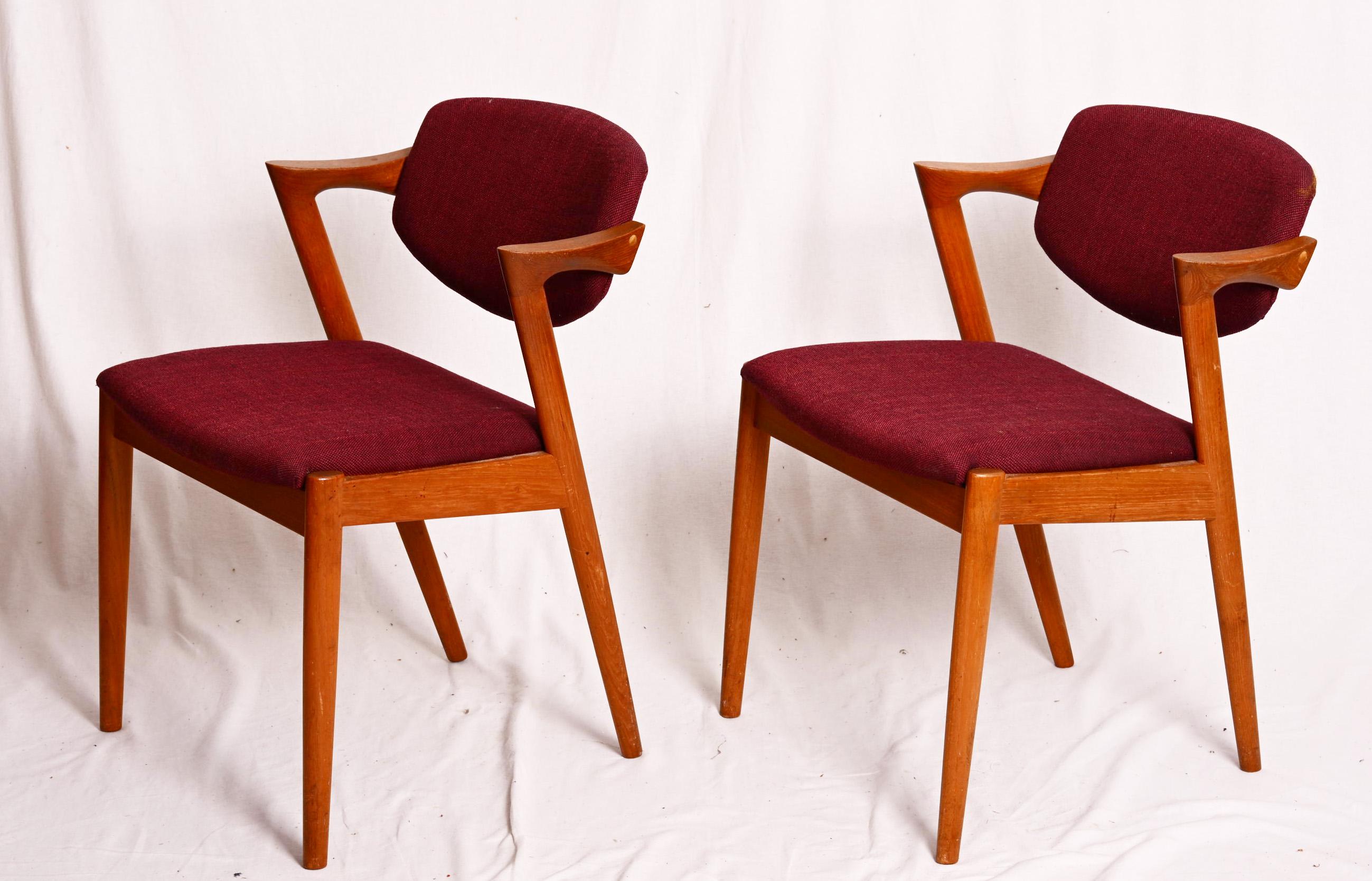Sillas de comedor, modelo 42, diseñadas por Kai Kristiansen y fabricadas en Dinamarca por Schou Andersen Møbelfabrik. Las sillas son de teca maciza, con patas cónicas, reposabrazos curvados y tapicería. Buen estado vintage. 
Precio de las dos
