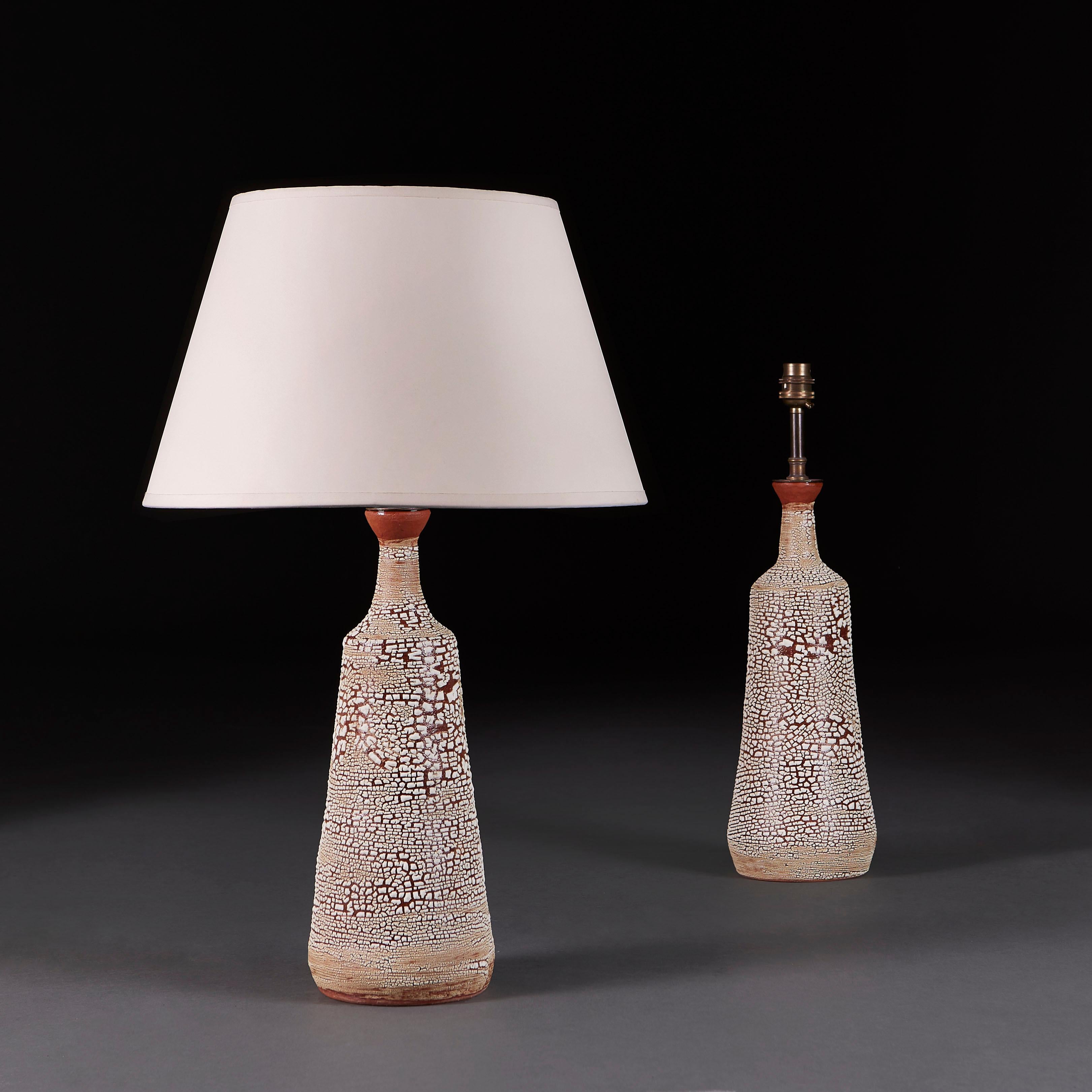 +VAT

England, modern

An unusual pair of terracotta vessels with tapering bottle necks and flared rims, decorated with a white crackle glaze, now mounted as lamps.

Height of vase 35.00cm
Height with shade 60.00cm
Diameter of base 13.00cm

Lead
