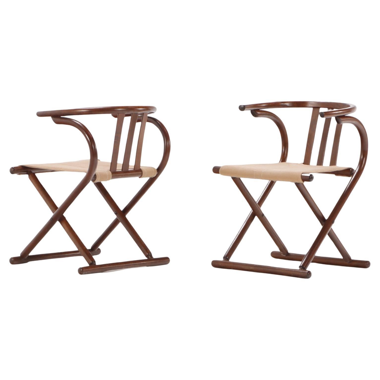 A pair of Thonet style folding sling chairs having downswept arms For Sale