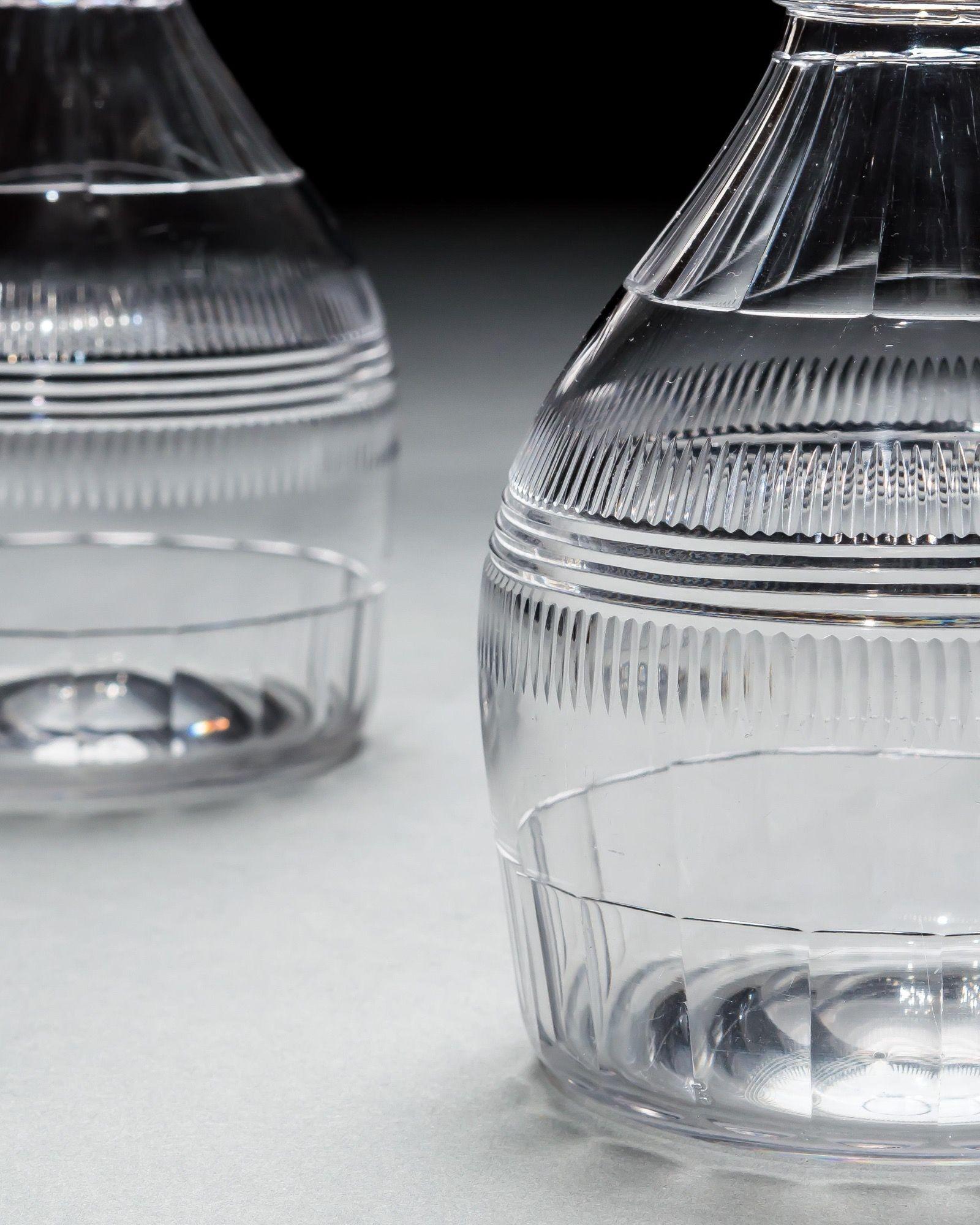 A pair of slice and step cut, triple ring Regency decanters fitted with sunburst stoppers.