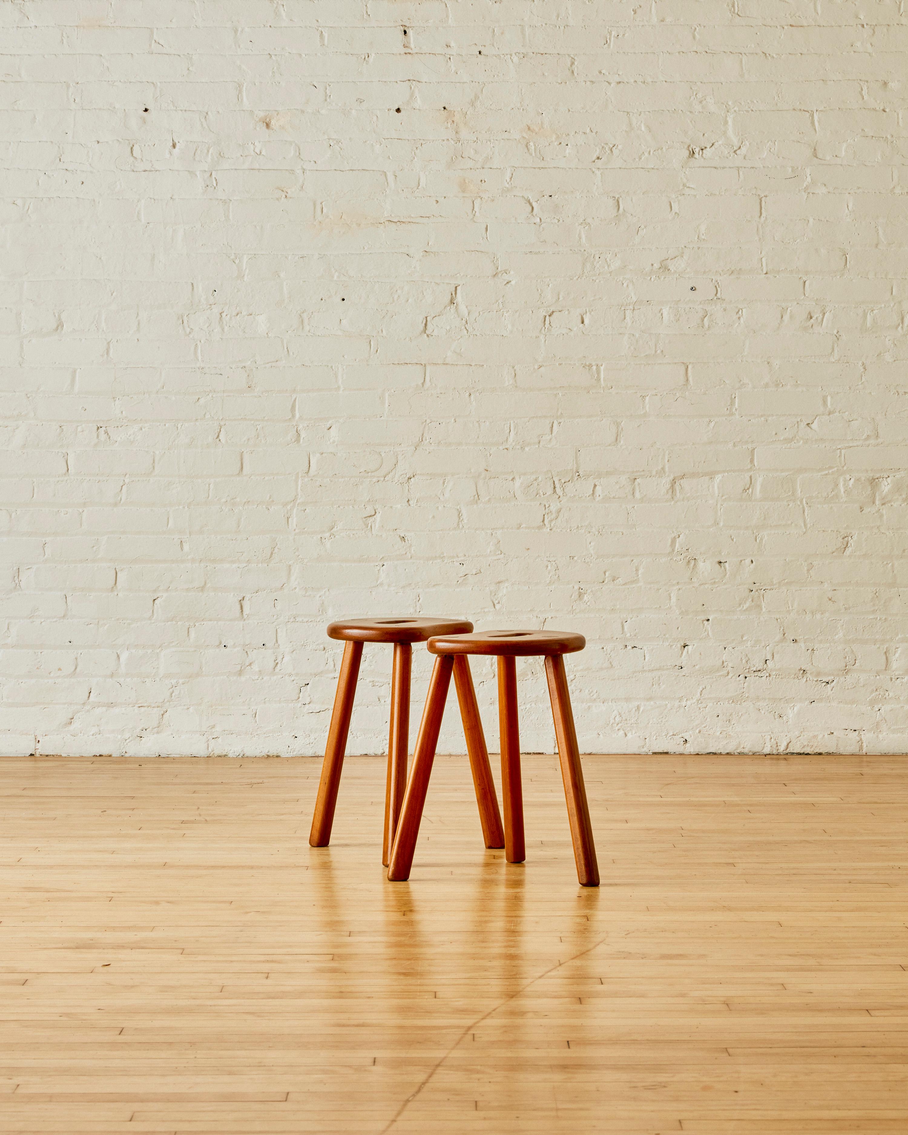 A Pair of Tripod Elm Wood Stools with oval openings on the seat. The stools can be sold individually for $1,400 each.

