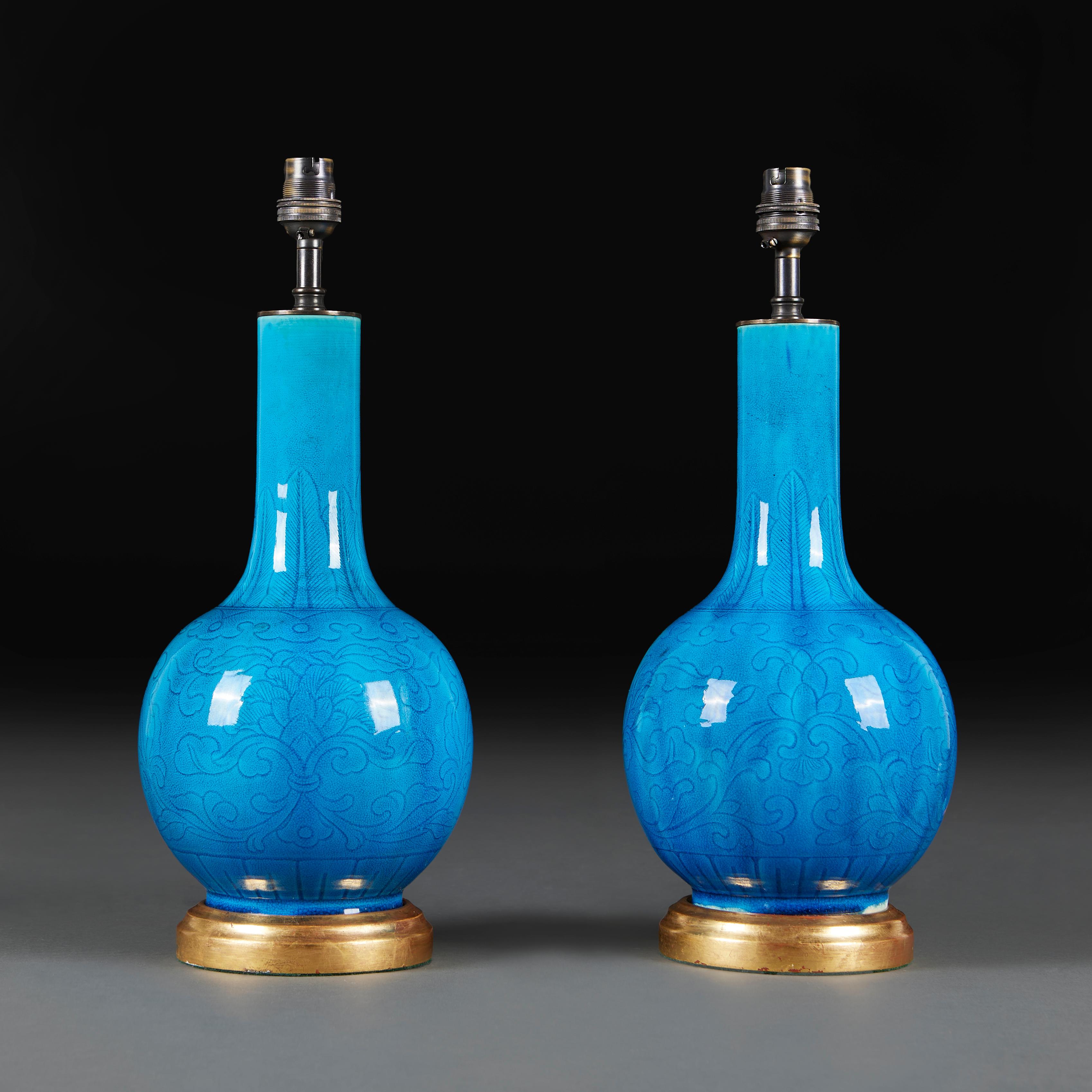 A fine pair of mid-19th century turquoise glazed bottle vases, with faint impressions of foliate designs on the bodies.

Please note:

Lampshade not included. Lamp photographed with a 16” diameter pale cream card Pembroke lampshade.

Currently wired