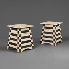 A pair of Tuscan style black and white painted side tables