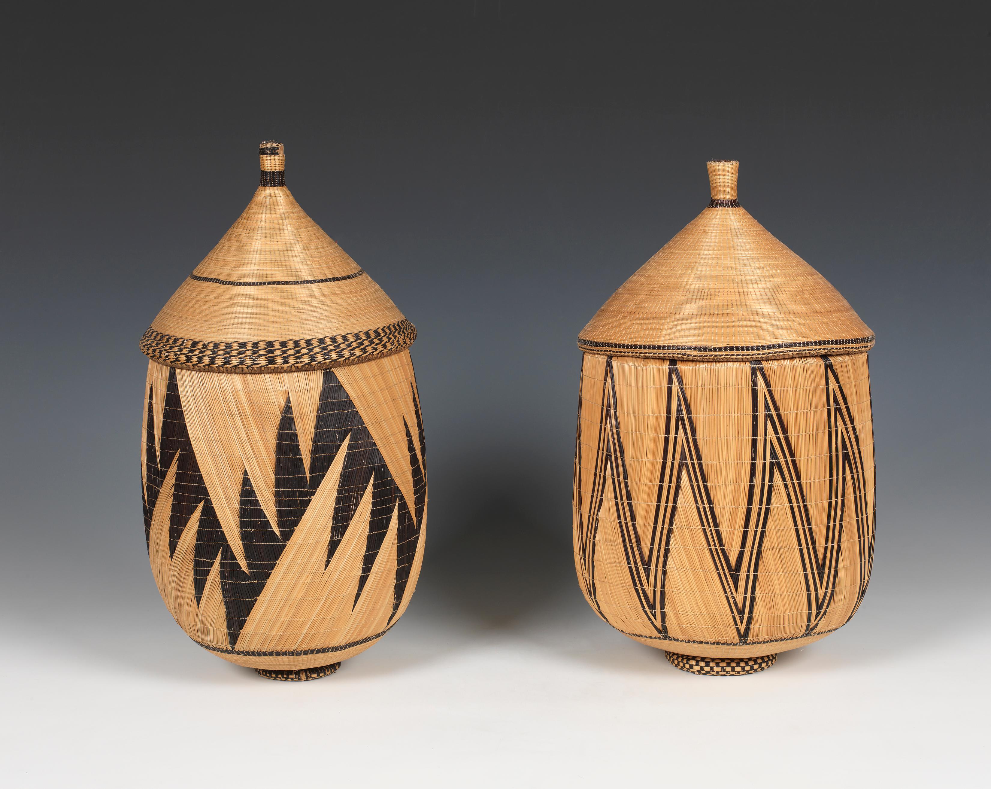 A Pair of Inkangara Prestige Baskets 
Rwanda or Burundi, Tutsi and Hutu peoples
20th century (1960s/1970s)
Left   H 16 1⁄2 ins (42 cm); D  8 1⁄2 ins (21.5 cm)
Right  H 16 ins (40.5 cm);  D 9 ins (23 cm)

Note the resemblance to the bold design and