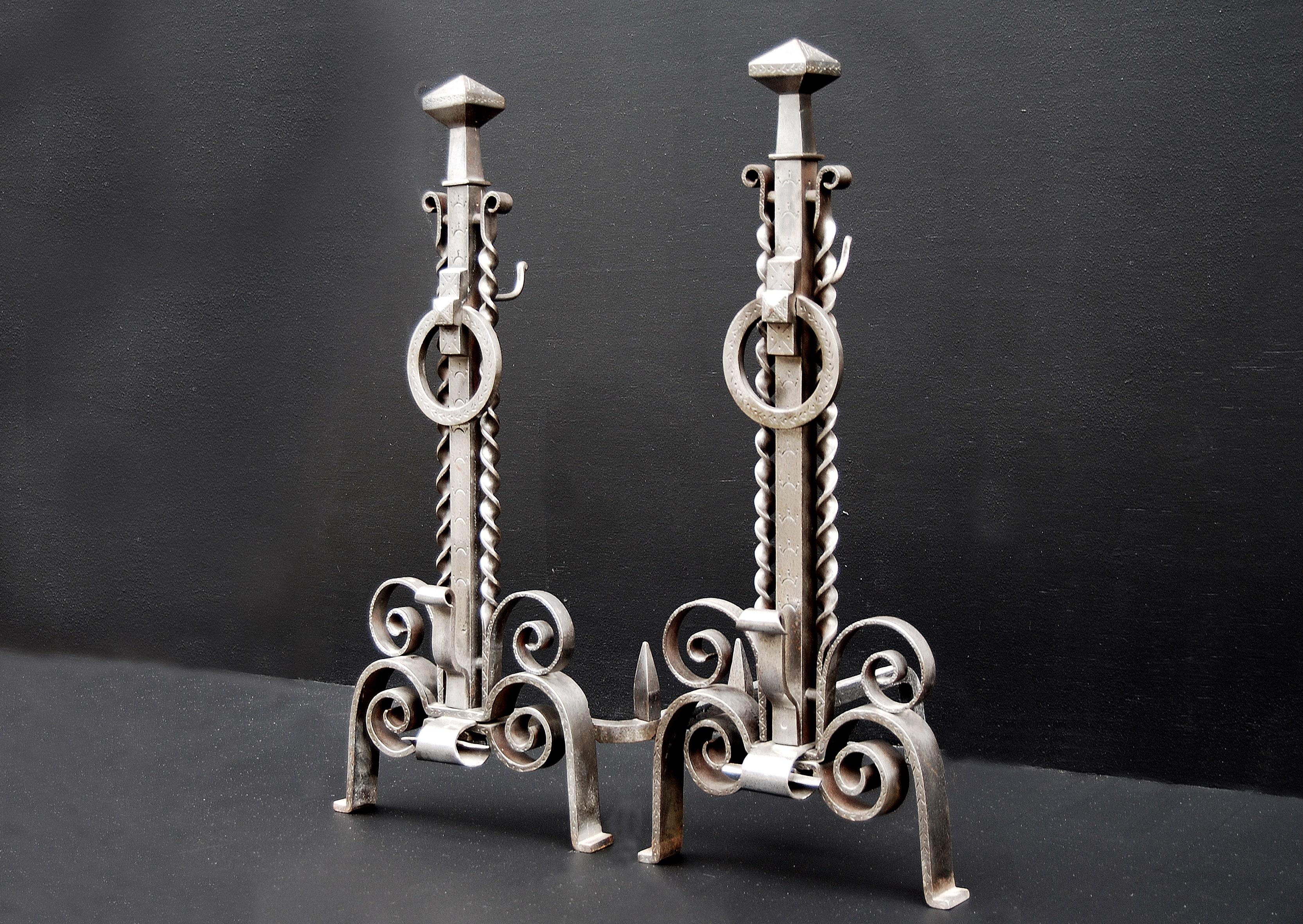 A pair of 19th century English polished and engraved steel firedogs. Scrolled bases, twists to shafts, and rings to fronts.

Measures: Height: 730 mm 28 ¾