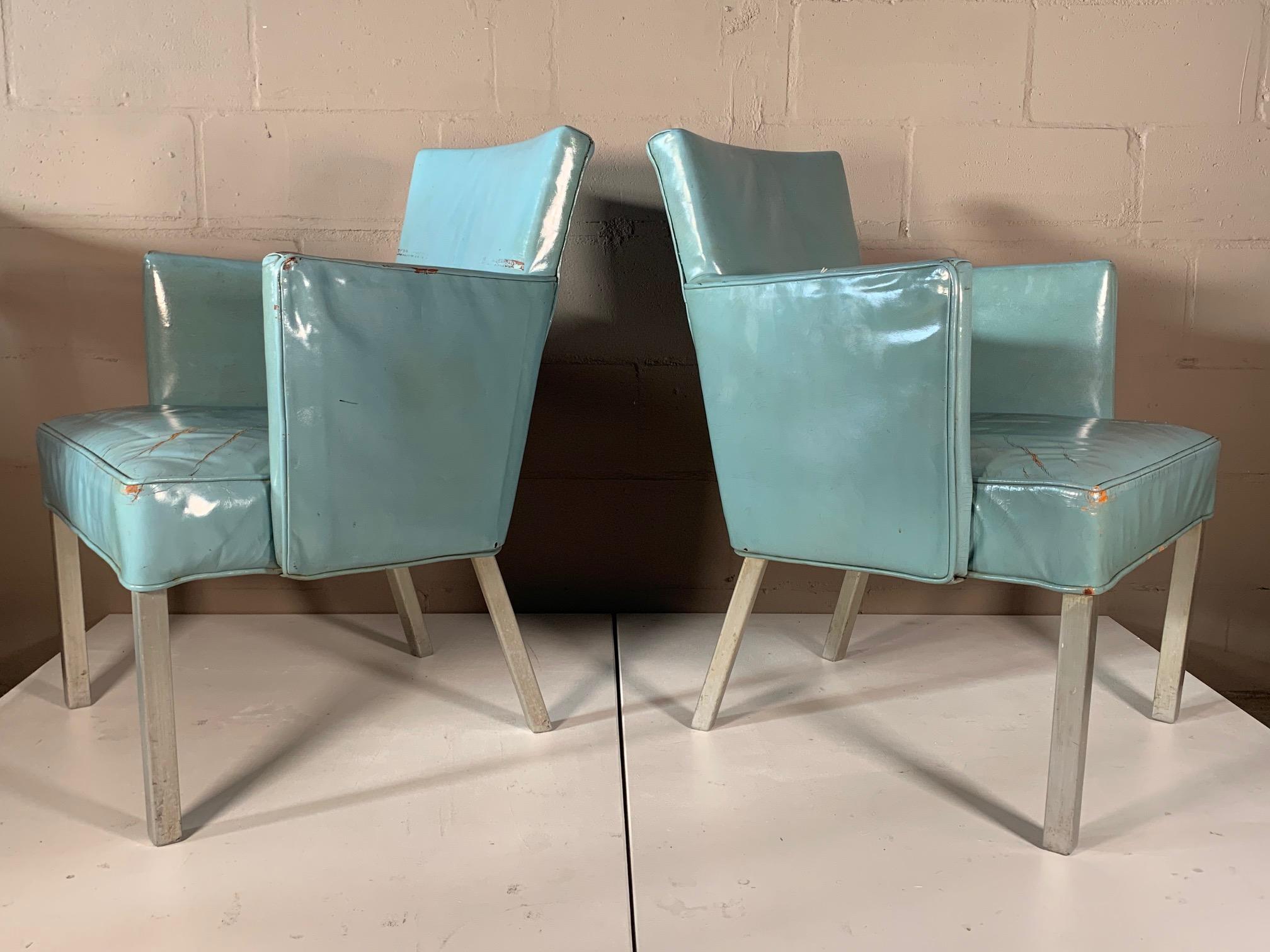 A pair of rare armchairs from the famed ocean liner SS United States. Retaining original patent blue leather, aluminum legs. Beautiful patina and historical rarity. 