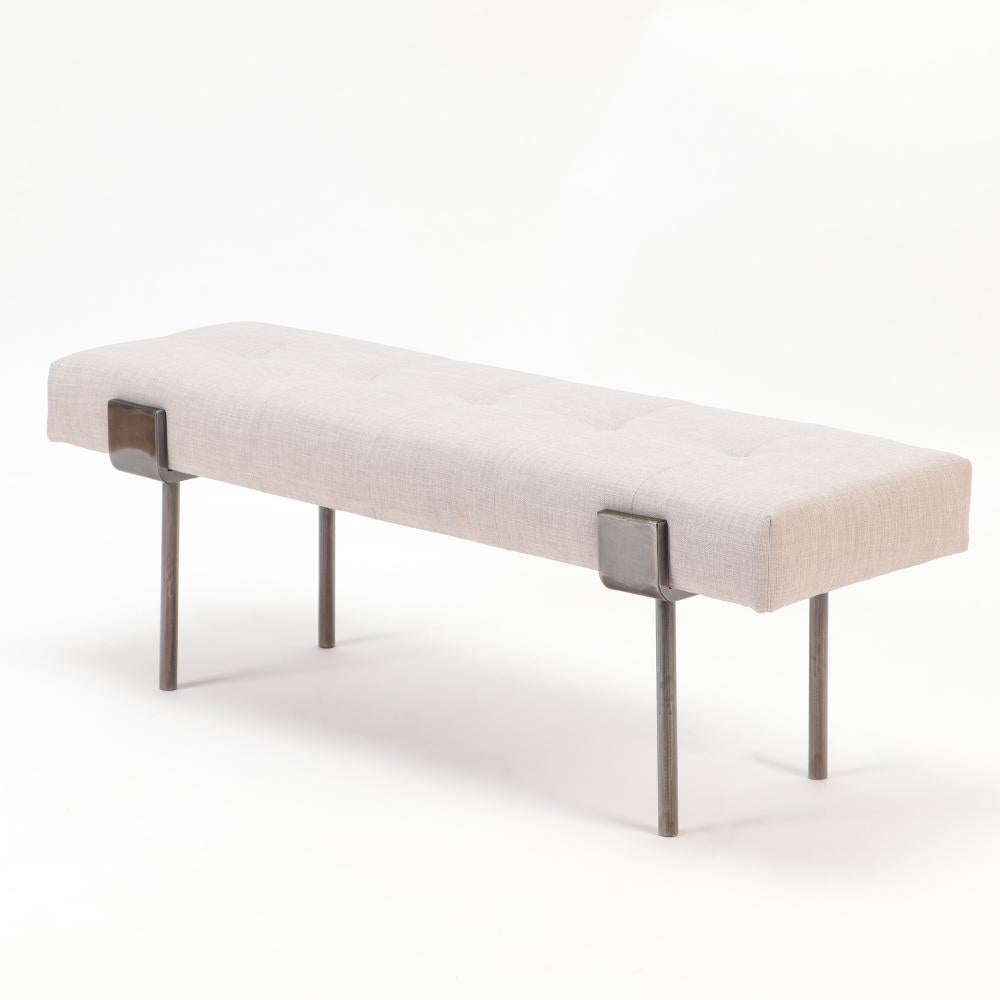 Un par de bancos de hierro tapizados. Contemporáneo. Los asientos en un fresco tapizado blanco apoyan sobre patas de diseño envolvente patinado en bronce. Asiento versátil para la entrada, el comedor o a los pies de la cama.