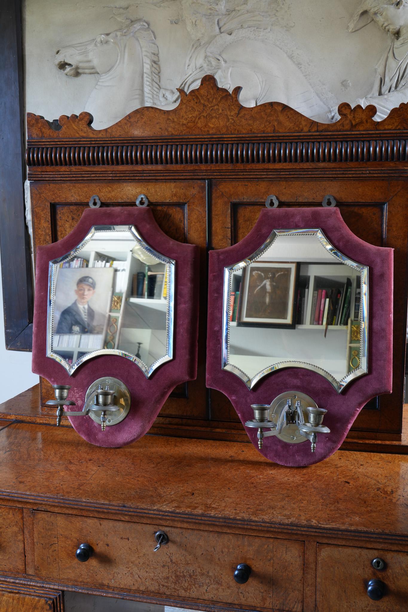 The shaped red velvet back board's mounted with brilliant cut and bevelled mirrors, twin brass candle sconces below.