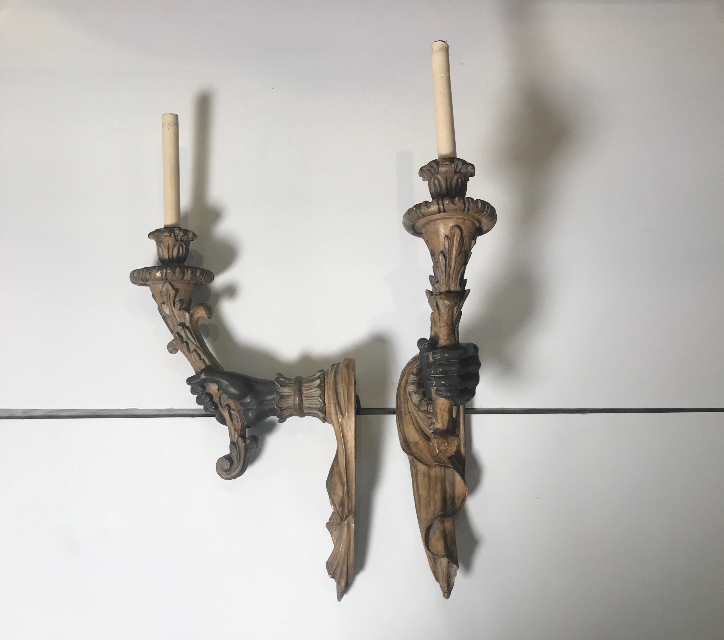 A pair of cast composition Venetian style sconces in a bronze and faux bois finish.