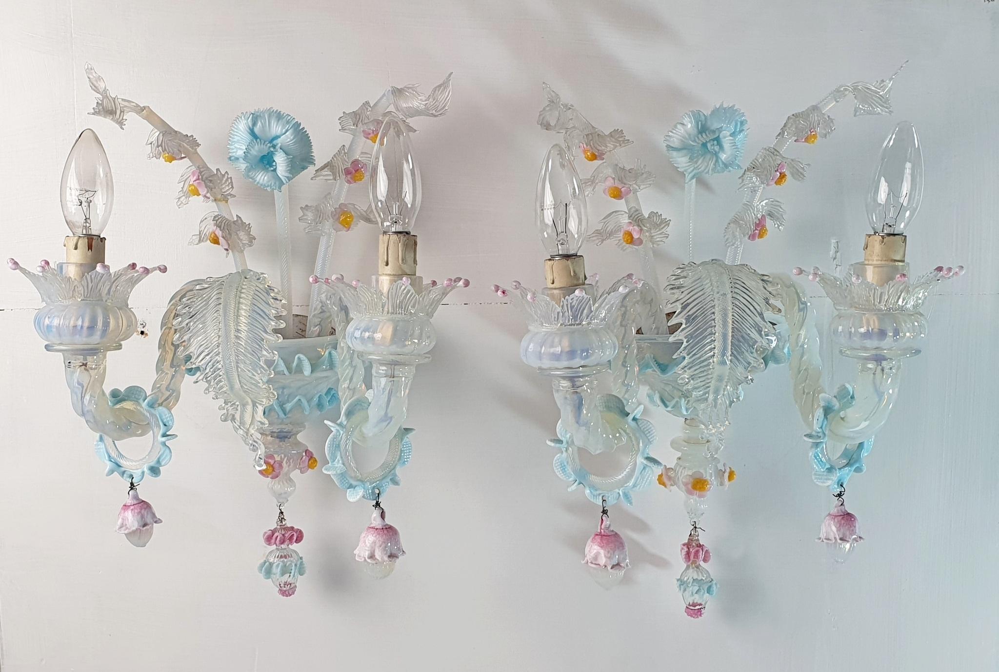 A nice pair of classic Murano sconces in Venetian style in milky white glass and soft pastels in pink, blue and yellow colored glass giving the light a nice shimmer. The sconces are handmade in Murano and are complete with flowers in the middle of