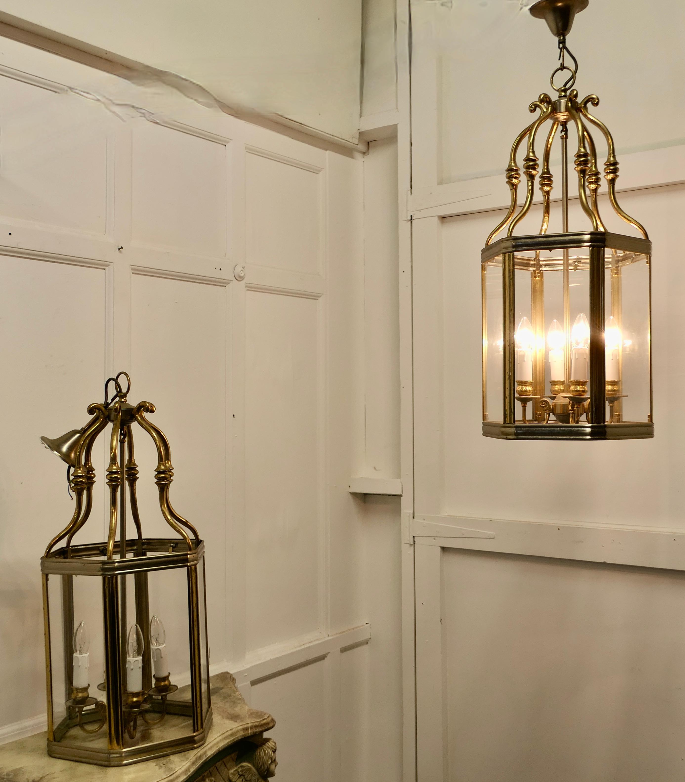 A pair of very large French Art Deco brass & glass hall lanterns

A superb impressive pair of brass lanterns, these have 6 clear glass sides with 4 bulb holders on the inside, they each hang on a brass ceiling rose
The lanterns give a sensational