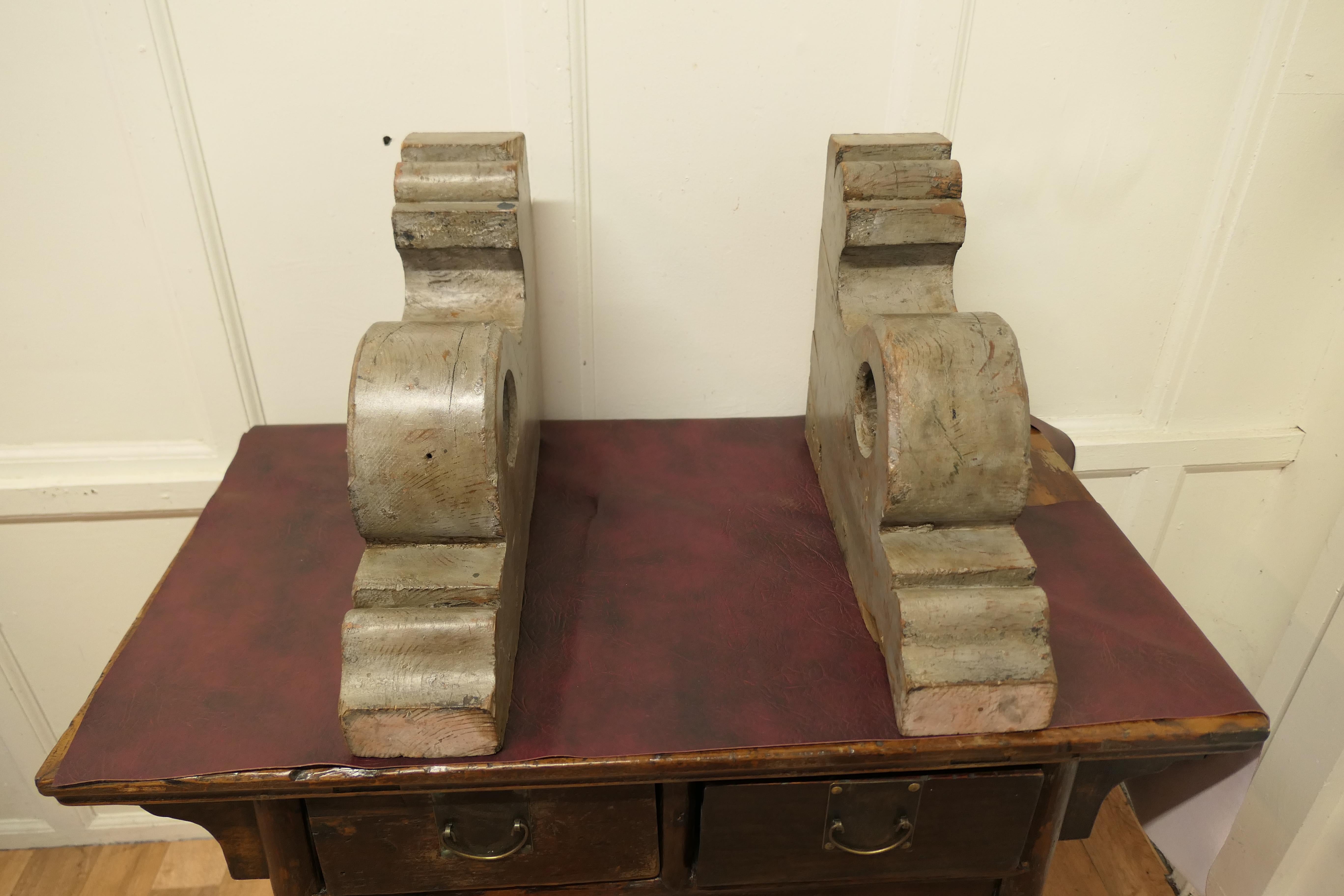 A pair of very large painted wall brackets.

The brackets are in 5” wide solid wood with old silver blue/grey paint, they are over 1ft high and has are deeply moulded. They do have a hole in the centre so they may have been made for a curtain rod