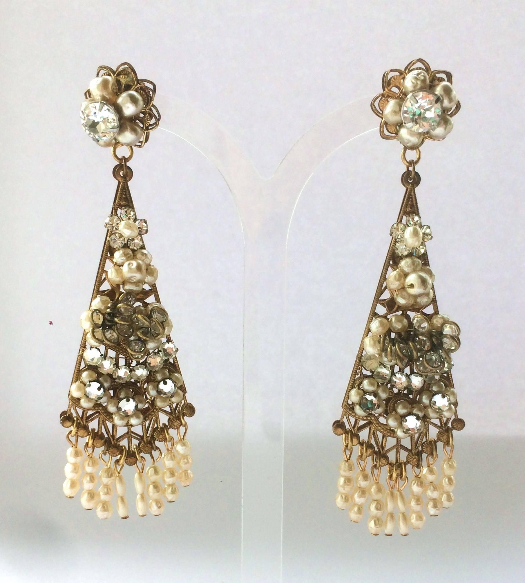 Stunning and dramatic, very long 'chandelier' earrings, hand made, from the 1950s by Robert de Mario. With long baroque pearl fringing and gilt filigree backing, they are perfect as go-to earrings that cascade onto or past the shoulders!
Robert De