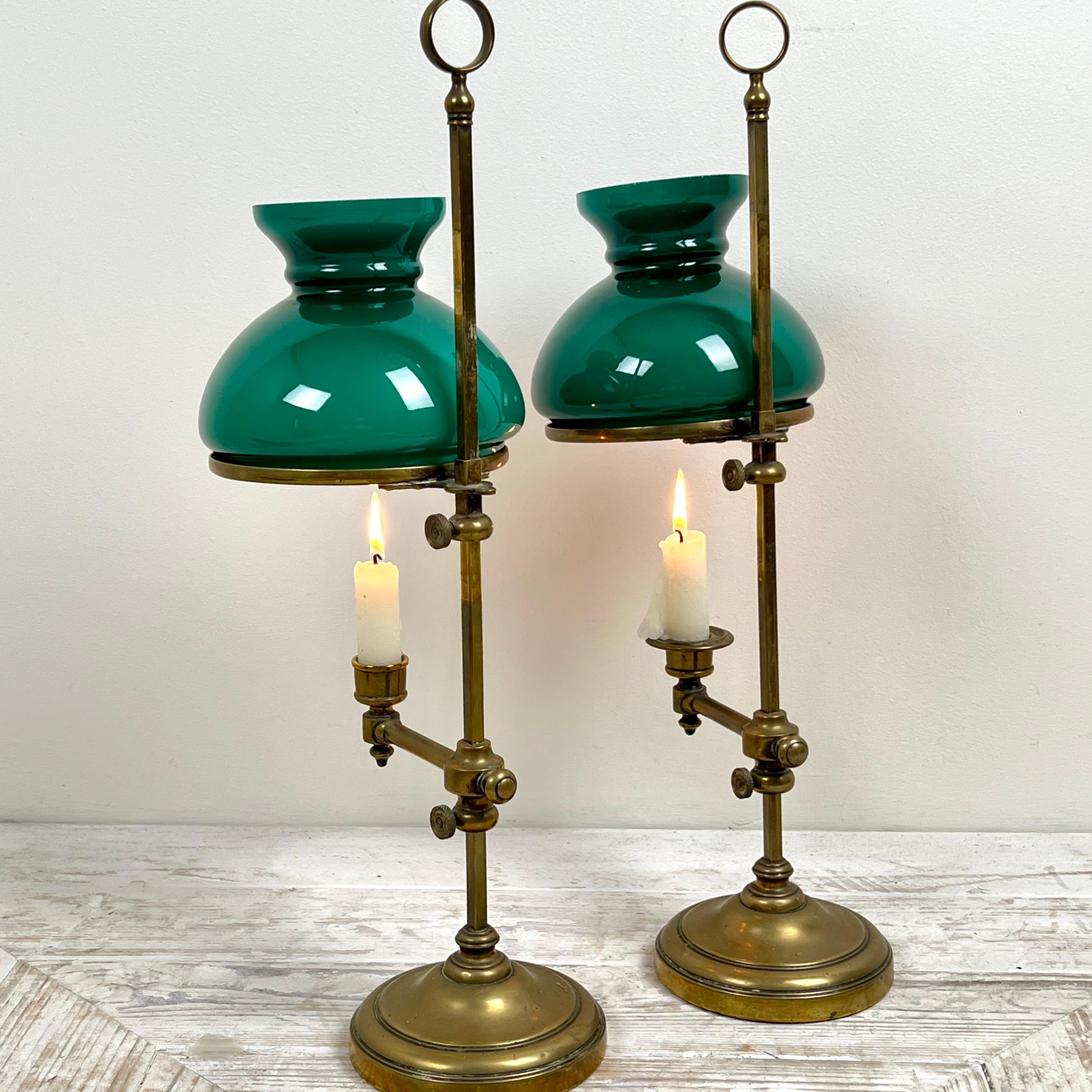 A Lovely Pair of Victorian Adjustable Brass Student's Candle Lamps

Each lamp features a classic domed green glass shade, held by a circular brass lip that can be adjusted via a turned brass thumb-screw.

Below the adjustable candle holder is