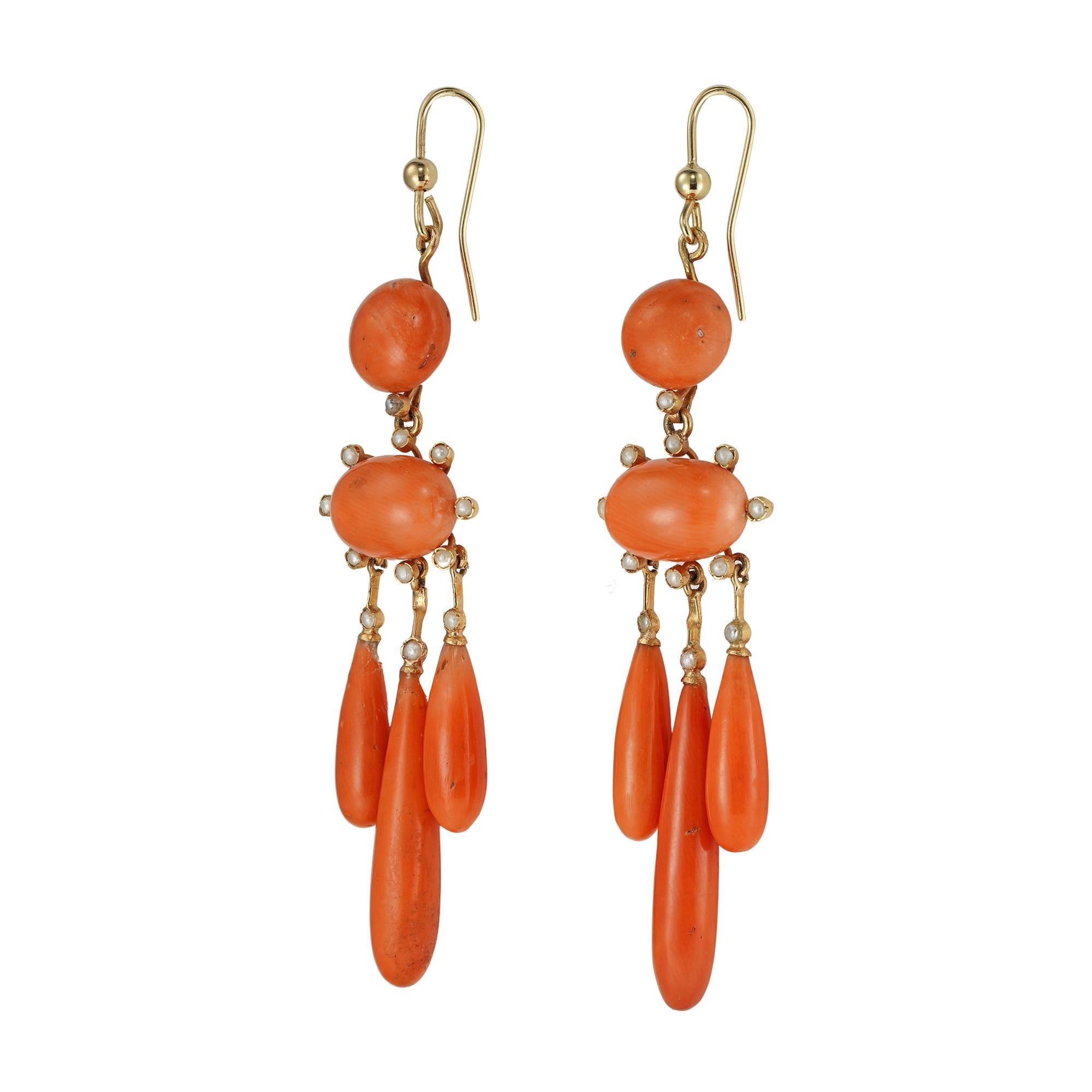 A pair of Victorian coral and pearl drop earrings, each consisting of a round button-shaped coral, suspending an oval button-shaped coral, measuring approximately 12.5x9mm, placed horizontally and surrounded by eight half seed pearls, further