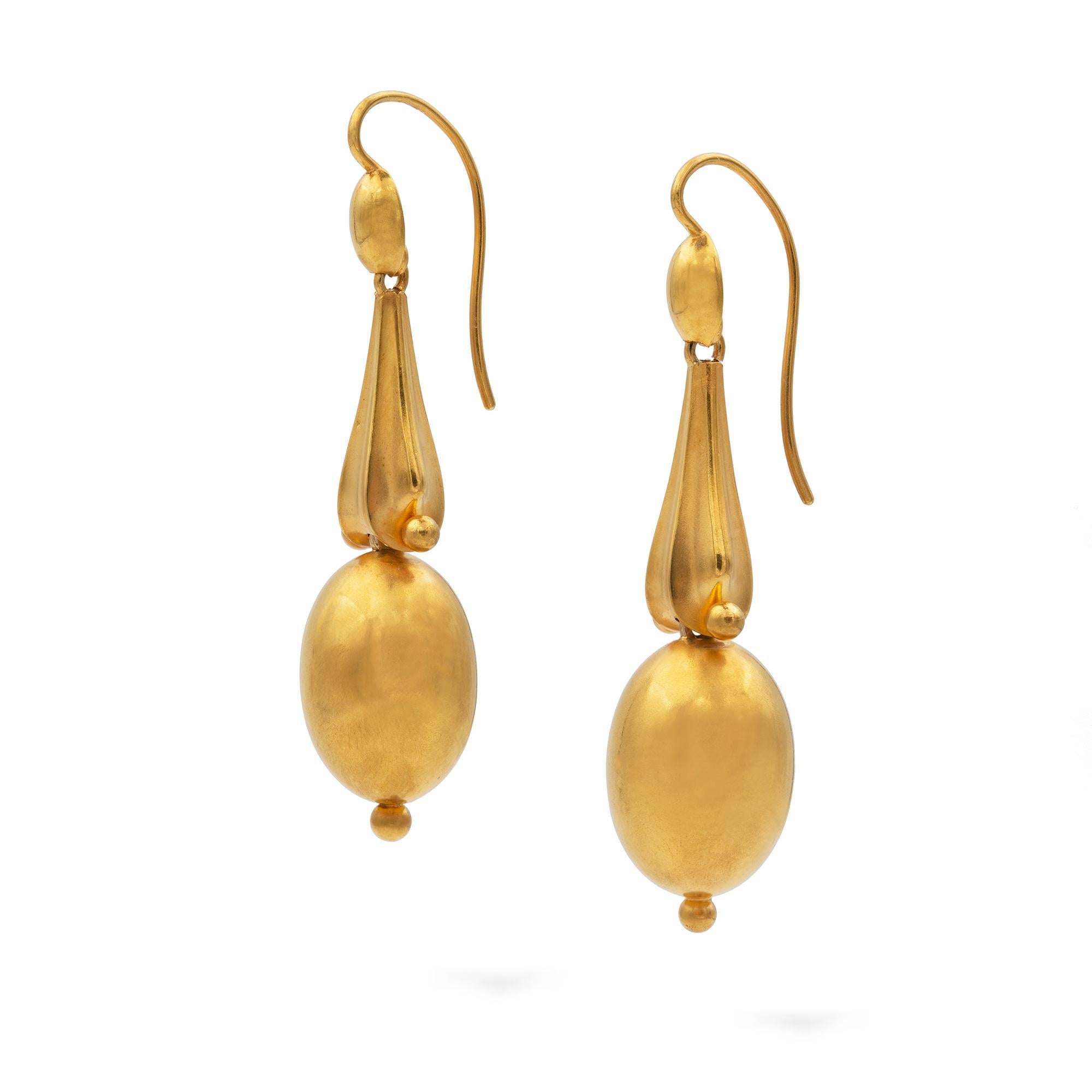 A pair of Victorian Etruscan Revival gold drop earrings, each earring consisting of a gold ovoid hollow-form drop, suspended from a gold curved hexagonal pyramid section, with a gold oval top and shepherds hook fitting, circa 1880, measuring 